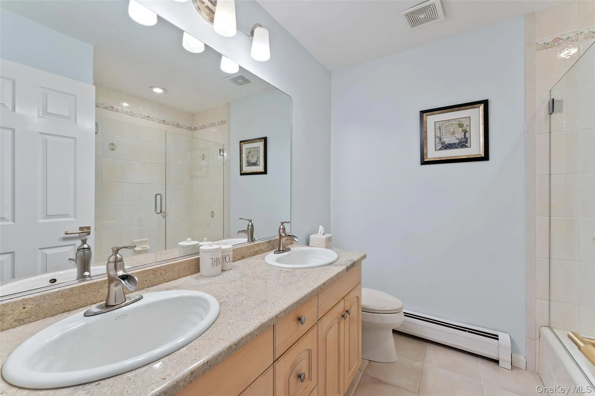 Bathroom featuring a baseboard heating unit, tile patterned flooring, and double vanity Bathroom featuring a baseboard heating unit, tile patterned flooring, and double vanity