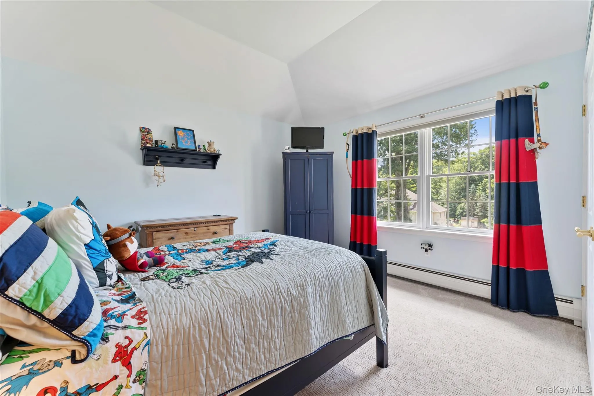 Carpeted bedroom featuring lofted ceiling and baseboard heating Carpeted bedroom featuring lofted ceiling and baseboard heating