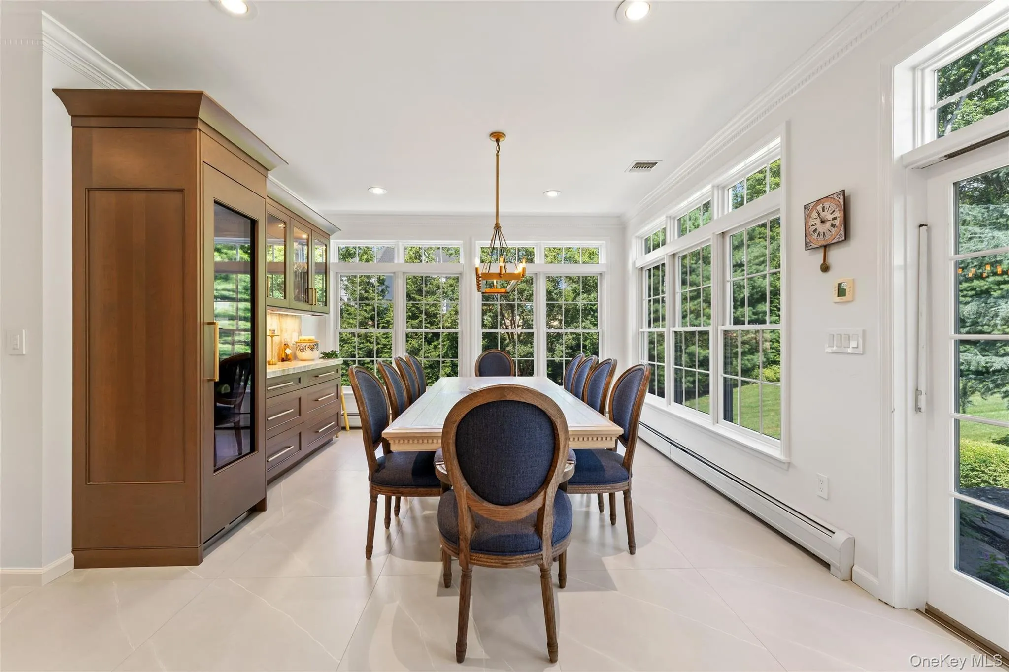 Sunroom with crown molding, a baseboard radiator, tile patterned flooring, recessed lighting, and a chandelier Sunroom with crown molding, a baseboard radiator, tile patterned flooring, recessed lighting, and a chandelier