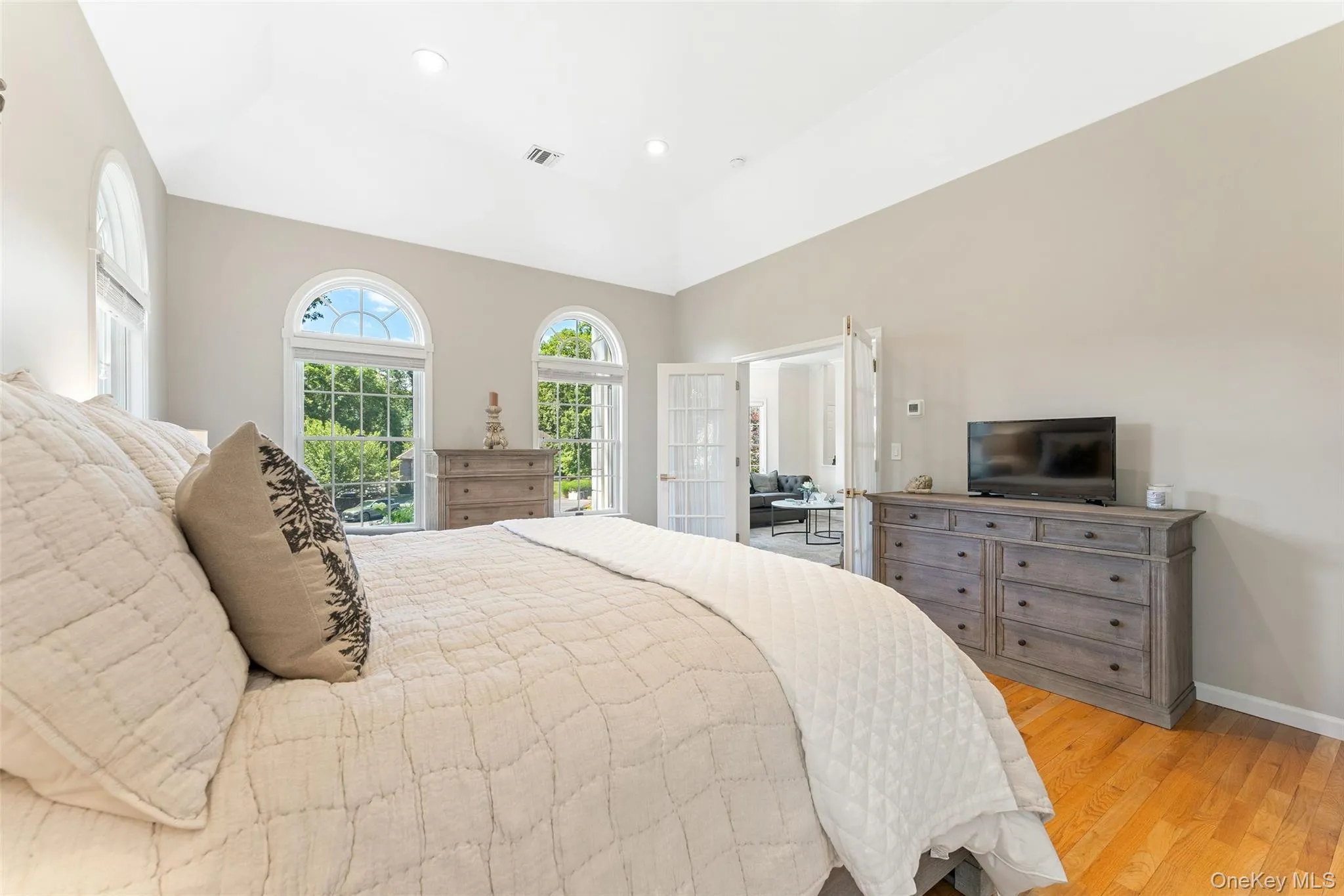 Bedroom with light wood-style floors, recessed lighting, and vaulted ceiling Bedroom with light wood-style floors, recessed lighting, and vaulted ceiling