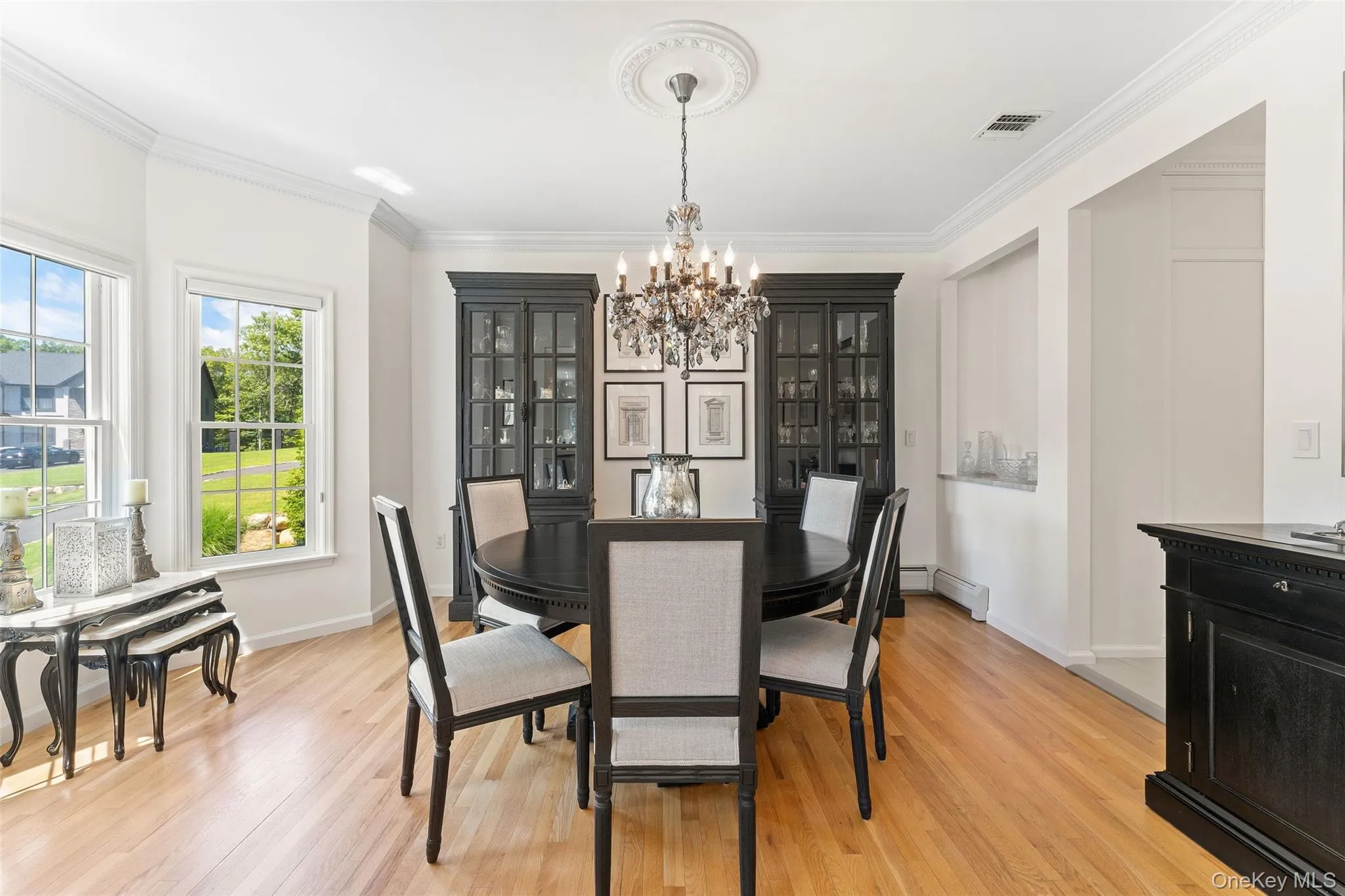Dining room featuring a chandelier, ornamental molding, and light wood-style floors Dining room featuring a chandelier, ornamental molding, and light wood-style floors