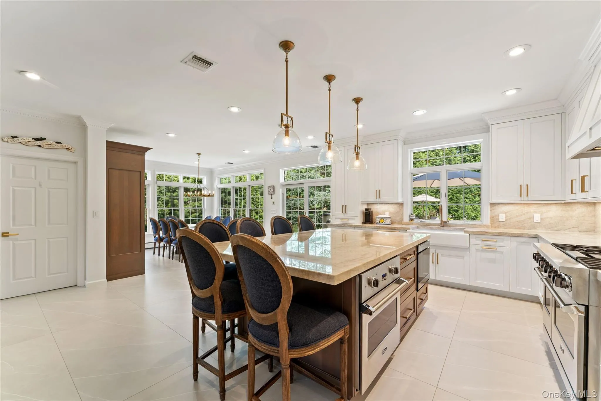 Kitchen with ornamental molding, tasteful backsplash, stainless steel appliances, a breakfast bar area, and light stone countertops Kitchen with ornamental molding, tasteful backsplash, stainless steel appliances, a breakfast bar area, and light stone countertops