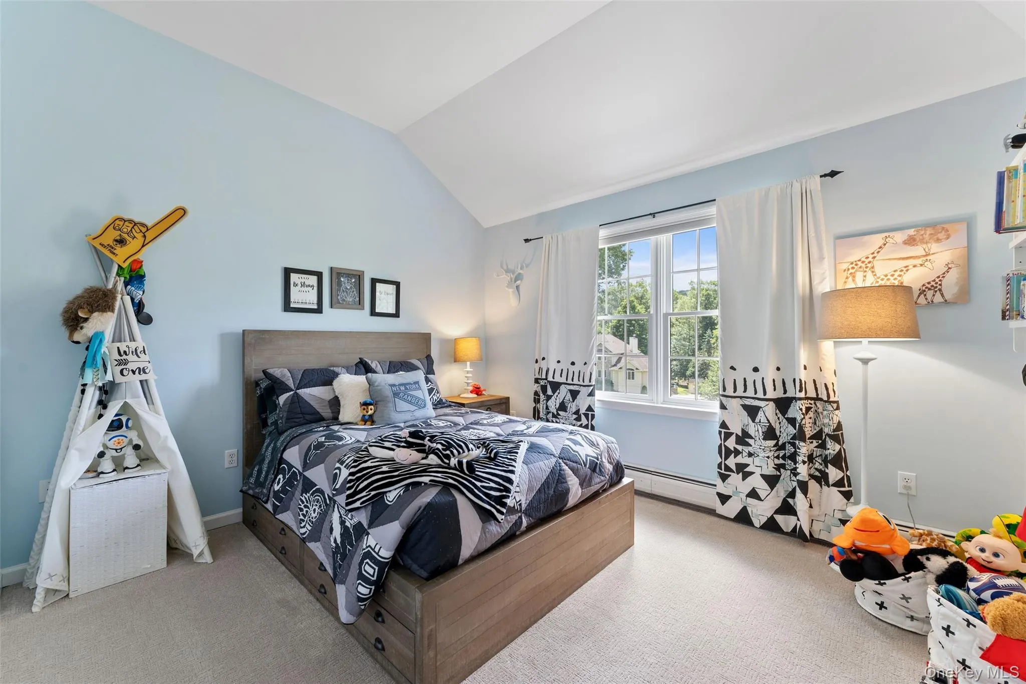 Carpeted bedroom with vaulted ceiling and baseboards Carpeted bedroom with vaulted ceiling and baseboards