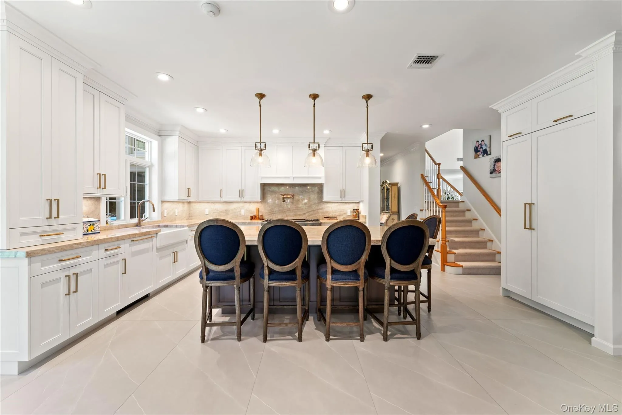 Kitchen featuring white cabinetry, an island with sink, a kitchen breakfast bar, recessed lighting, and decorative backsplash Kitchen featuring white cabinetry, an island with sink, a kitchen breakfast bar, recessed lighting, and decorative backsplash