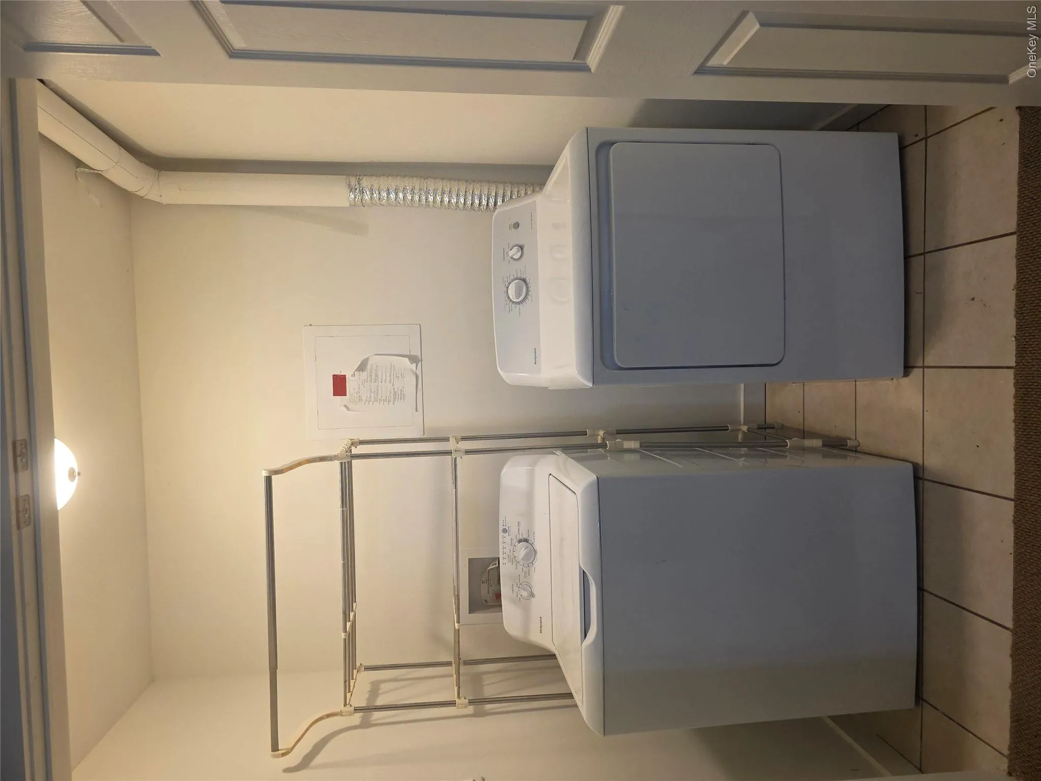 Clothes washing area featuring laundry area, washing machine and clothes dryer, and light tile patterned floors Clothes washing area featuring laundry area, washing machine and clothes dryer, and light tile patterned floors