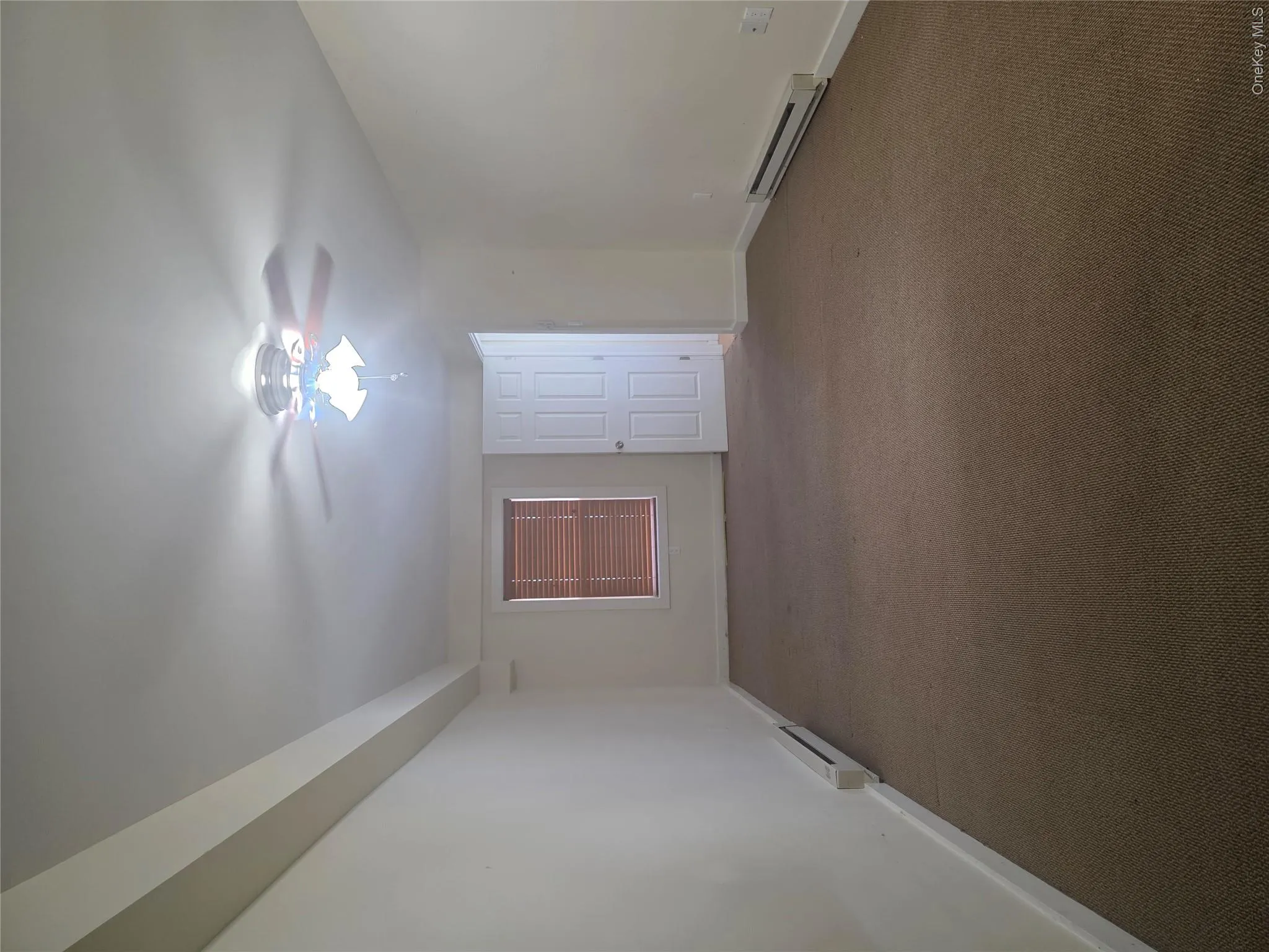 Carpeted empty room with baseboard heating and baseboards Carpeted empty room with baseboard heating and baseboards