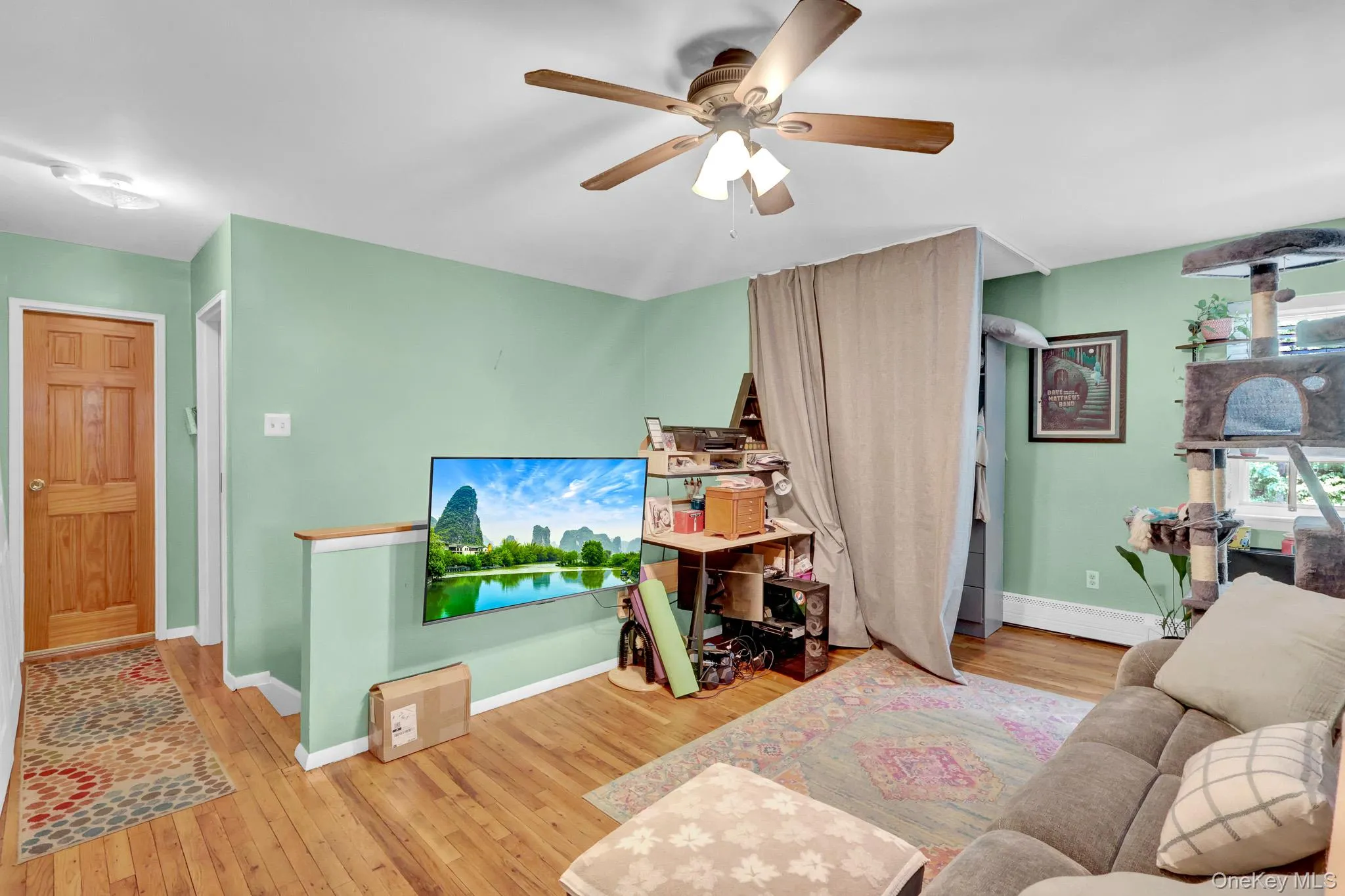 Light green walls complementing wood-finish flooring throughout the space Light green walls complementing wood-finish flooring throughout the space