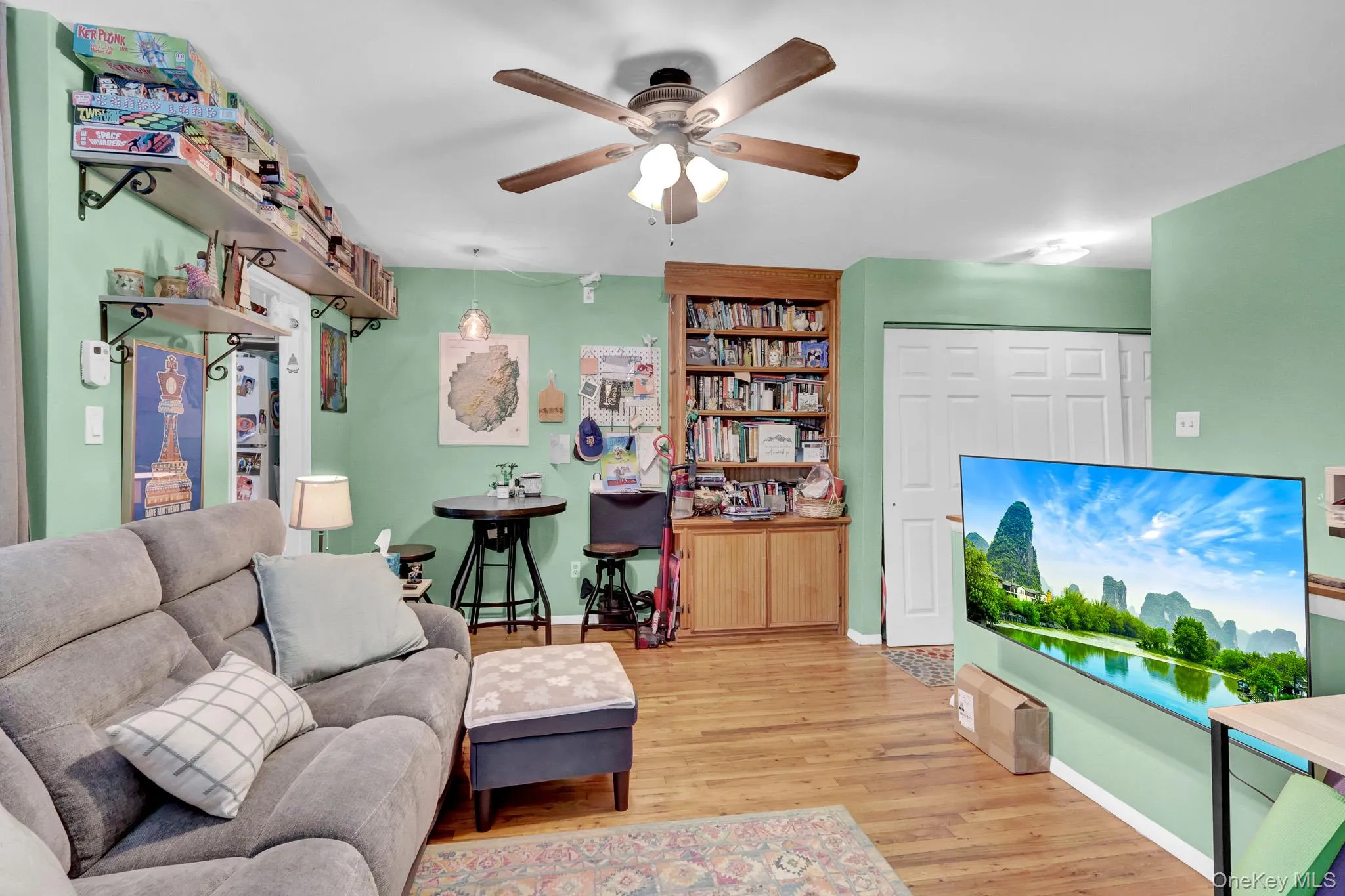 Living area featuring wood-finish flooring, a ceiling fan with light kit, and recessed lighting Living area featuring wood-finish flooring, a ceiling fan with light kit, and recessed lighting
