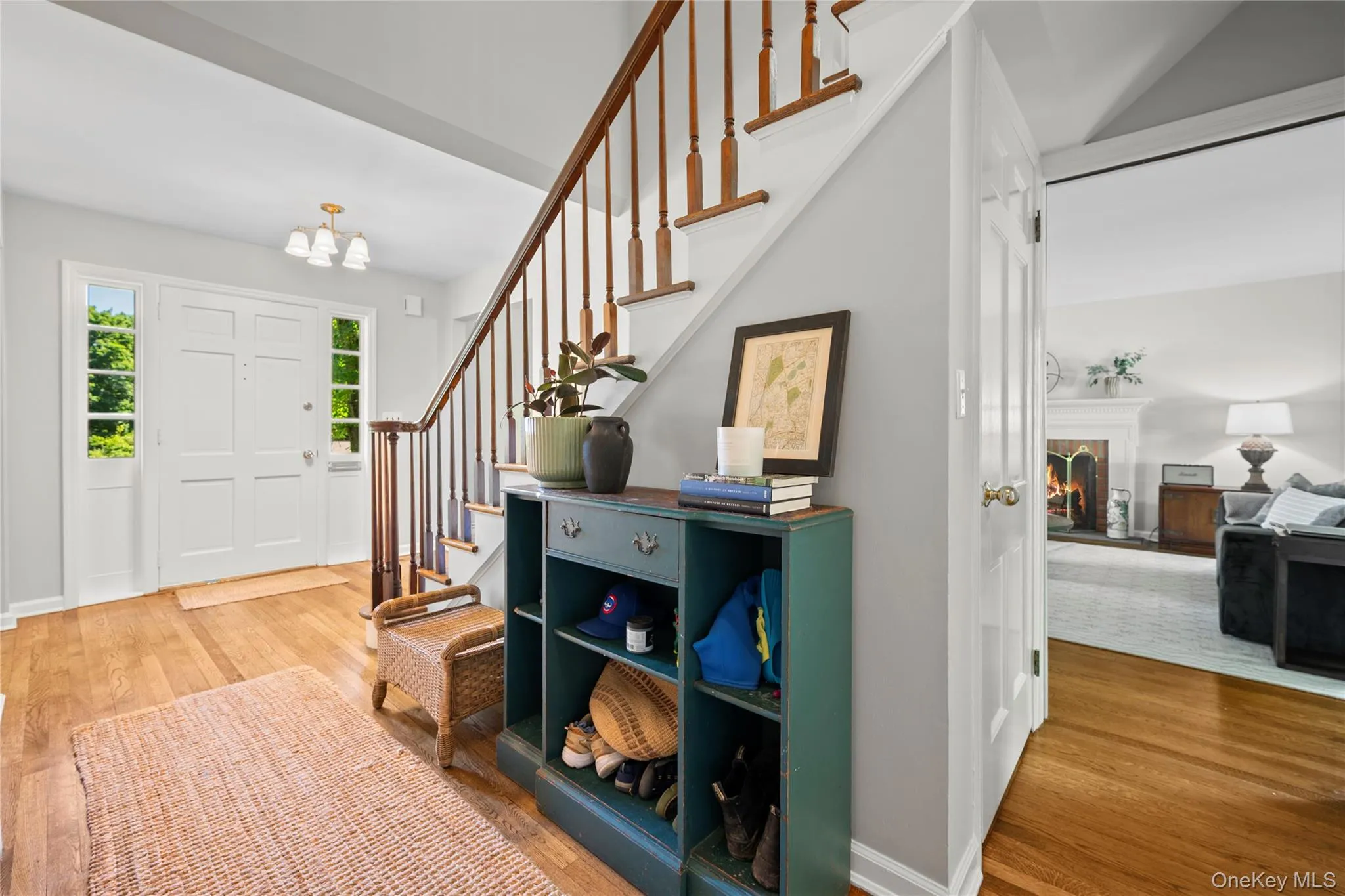 Foyer with hardwood flooring, a multi-pane front door with side lights, and a staircase to the second floor. Foyer with hardwood flooring, a multi-pane front door with side lights, and a staircase to the second floor.