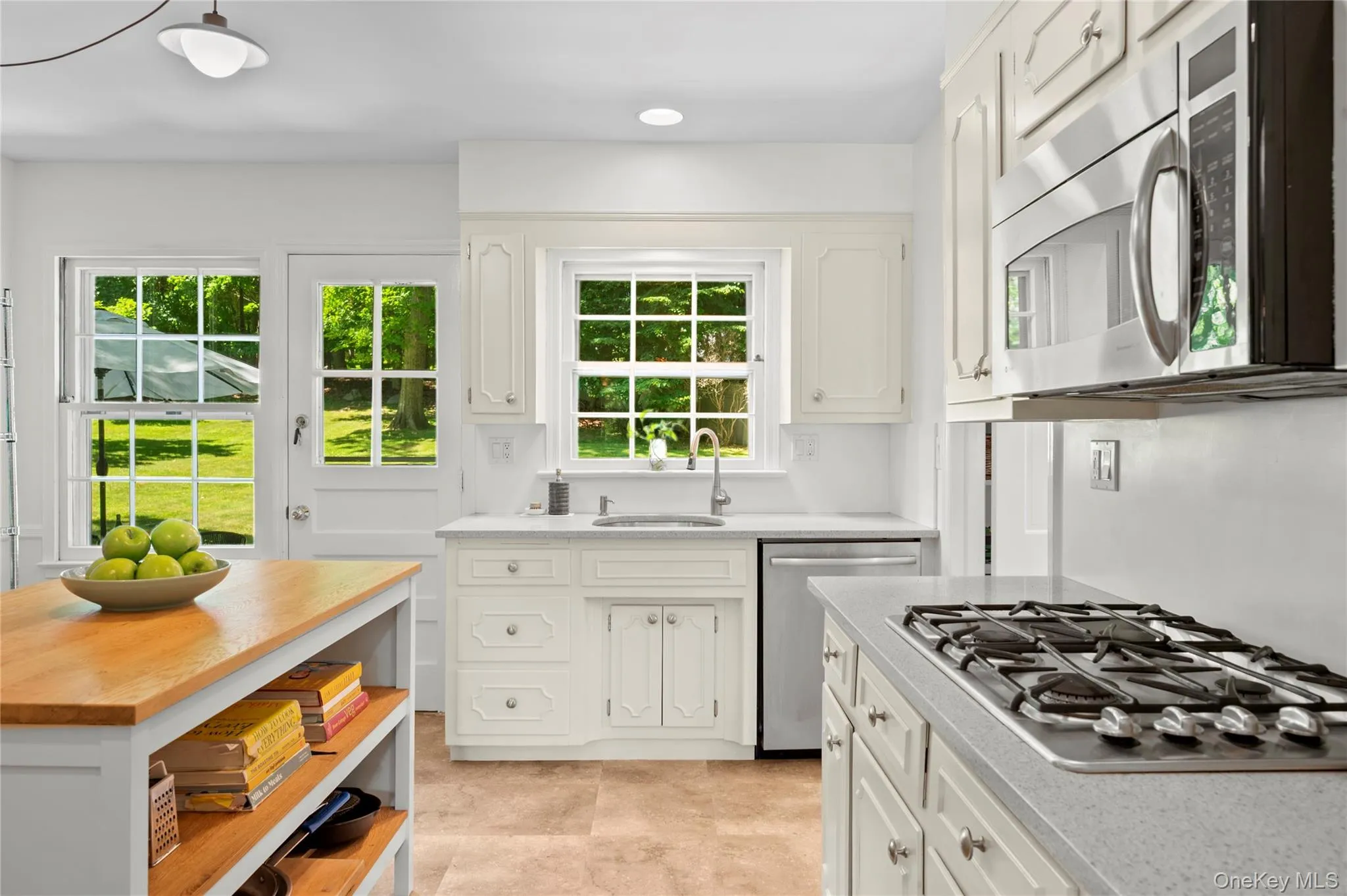 Kitchen featuring a built-in stainless steel microwave, a gas cooktop, and easy access to the patio Kitchen featuring a built-in stainless steel microwave, a gas cooktop, and easy access to the patio