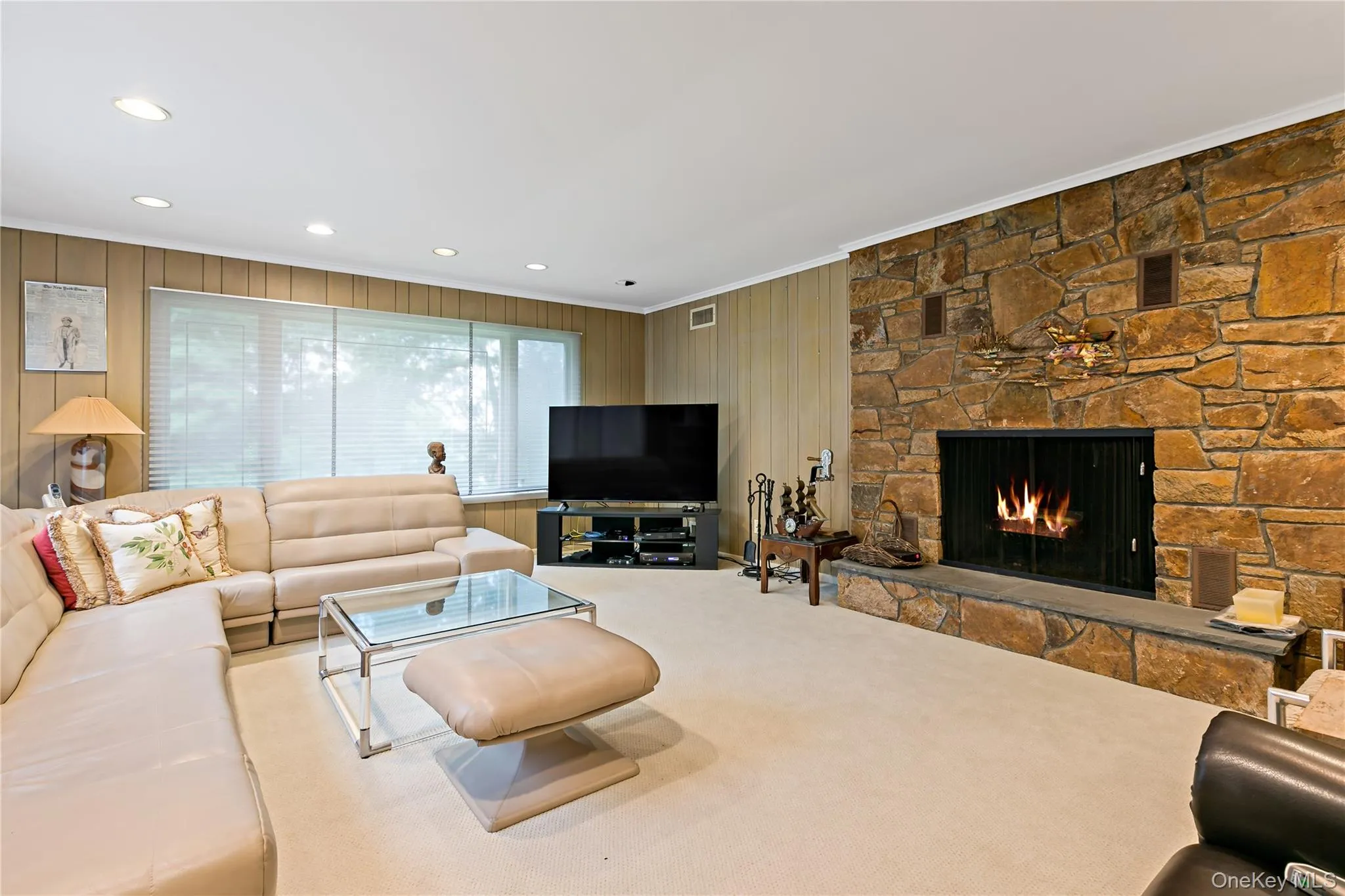 Family room featuring walls of windows with views of the golf course with wood burning fireplace Family room featuring walls of windows with views of the golf course with wood burning fireplace