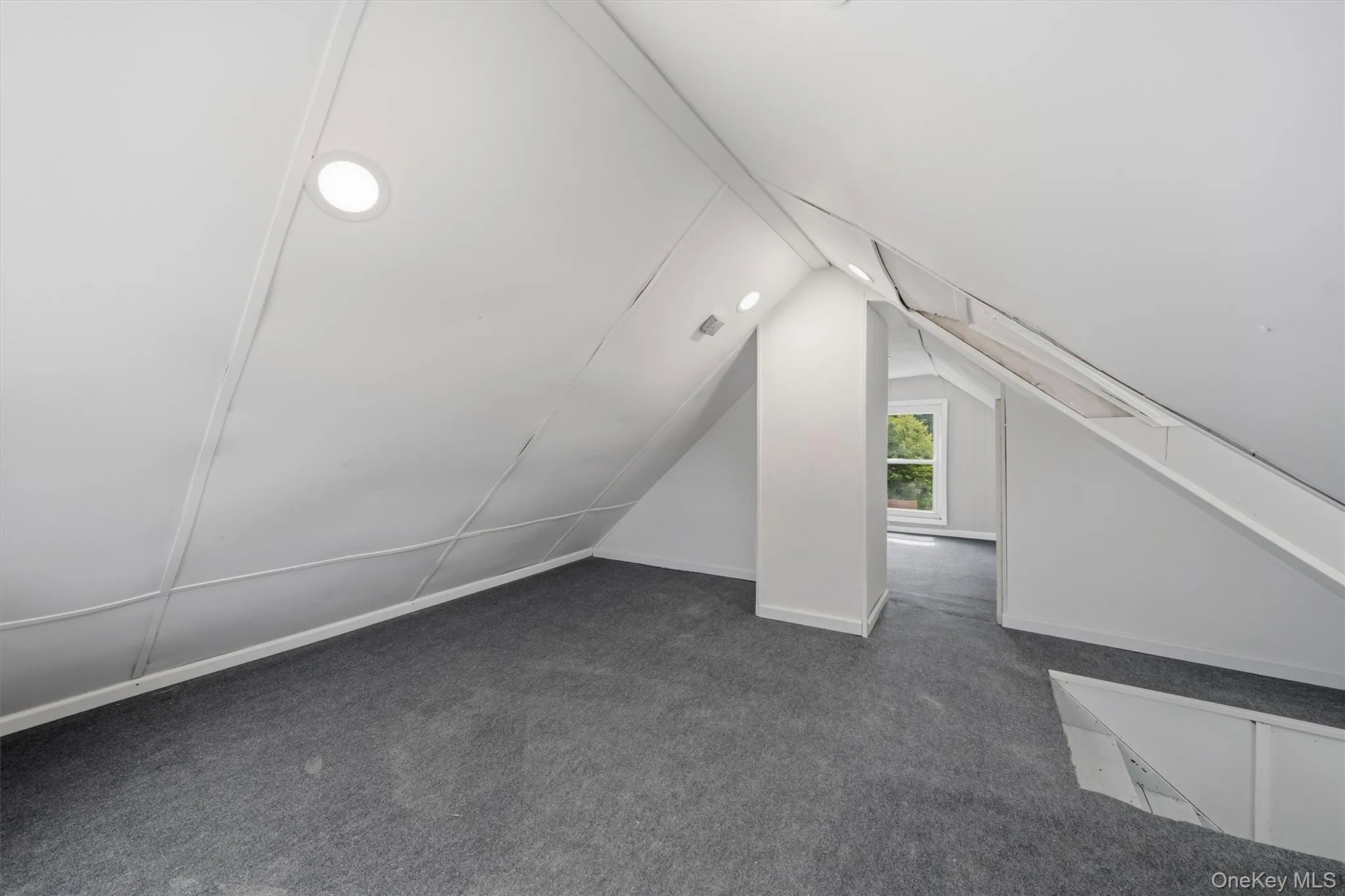 Partially finished attic with new carpeting. Partially finished attic with new carpeting.