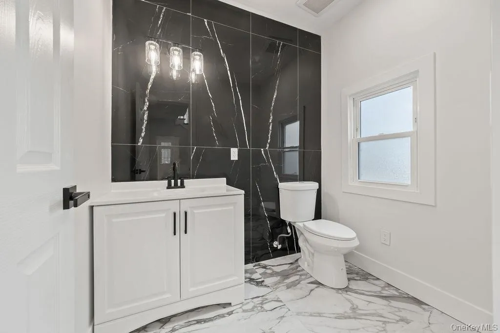 Bathroom featuring vanity and light marble finish flooring Bathroom featuring vanity and light marble finish flooring