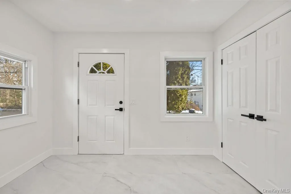 Foyer entrance featuring baseboards and light marble finish floors Foyer entrance featuring baseboards and light marble finish floors