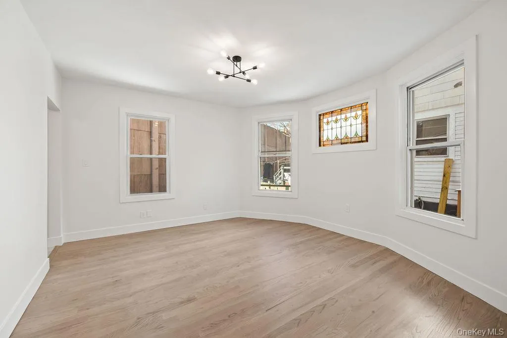 Spare room featuring light wood-style flooring and a chandelier Spare room featuring light wood-style flooring and a chandelier