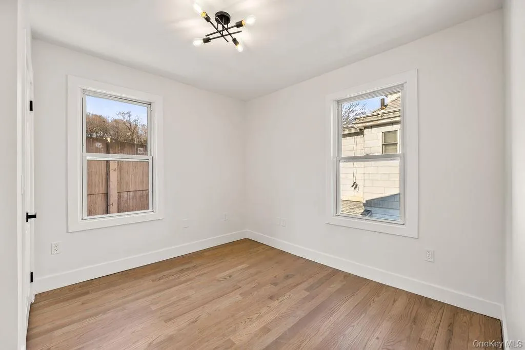 Unfurnished room with light wood finished floors and a chandelier Unfurnished room with light wood finished floors and a chandelier