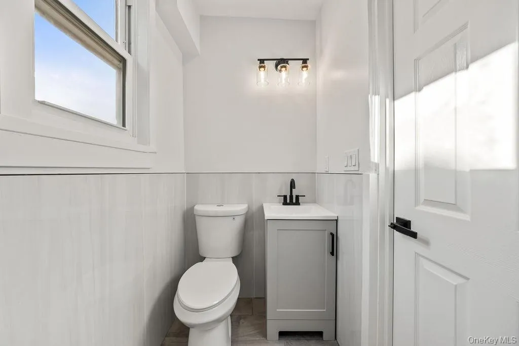 Half bath featuring vanity and a wainscoted wall Half bath featuring vanity and a wainscoted wall