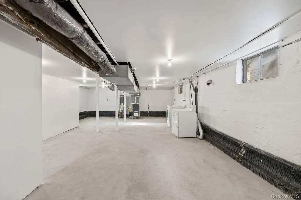 Unfinished basement with washer and clothes dryer and heating unit Unfinished basement with washer and clothes dryer and heating unit
