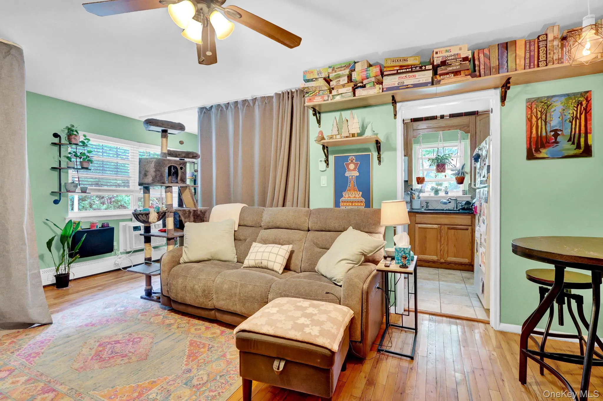 Living area with wood-finish flooring and a ceiling fan with integrated lighting Living area with wood-finish flooring and a ceiling fan with integrated lighting
