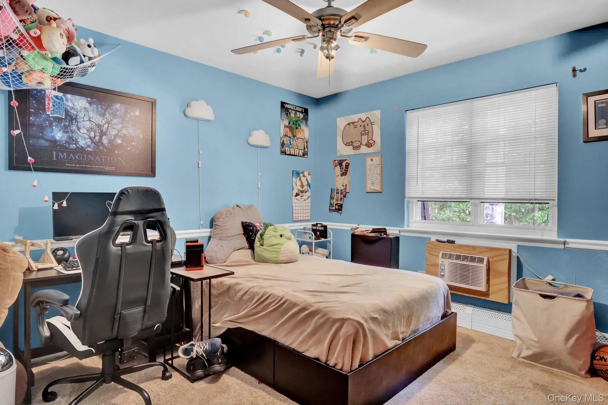 Carpeted room featuring a ceiling fan, a window with blinds, and a built-in window air conditioning unit Carpeted room featuring a ceiling fan, a window with blinds, and a built-in window air conditioning unit