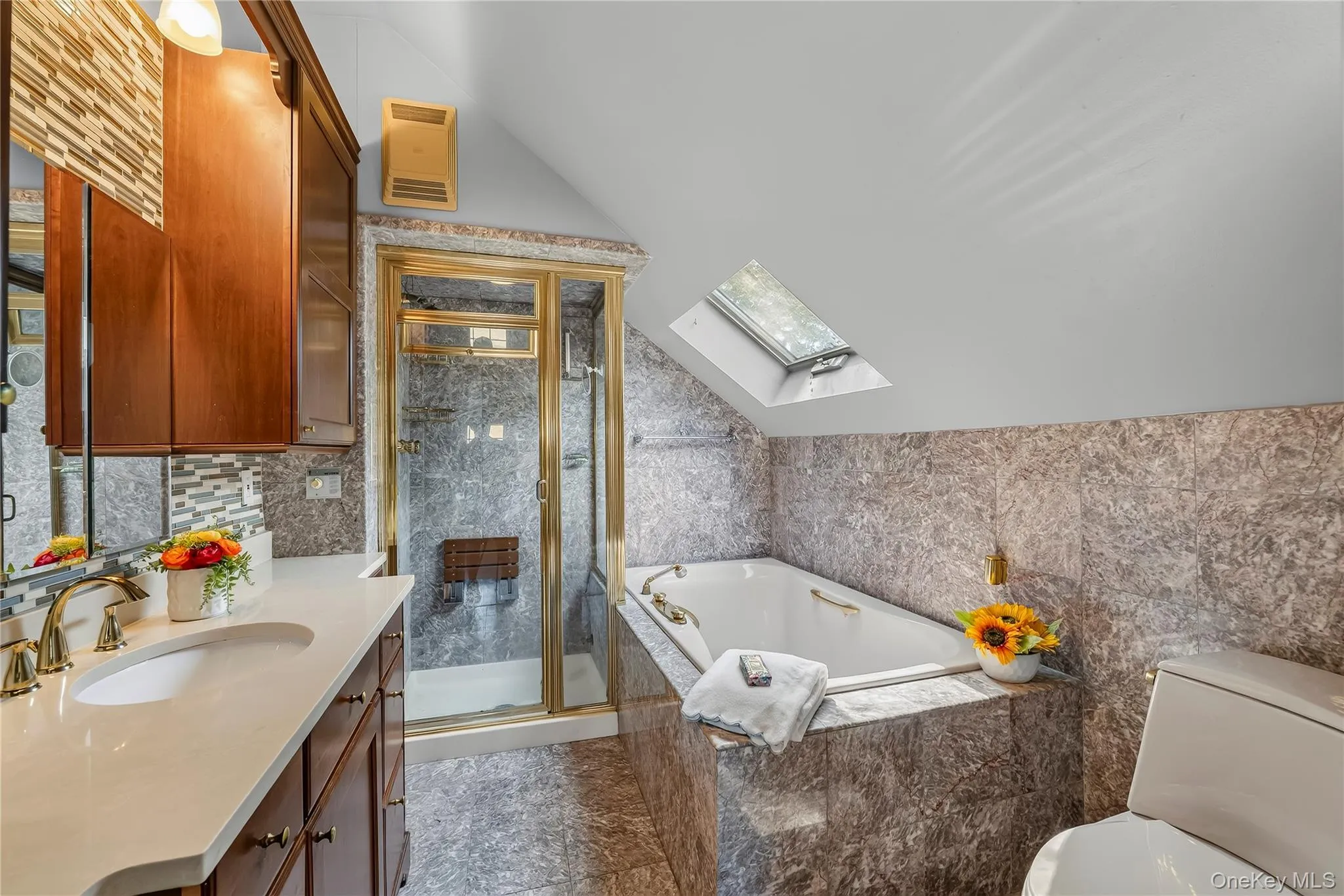 The ensuite spa bath features a whirlpool bath, skylight and stone vanity. The ensuite spa bath features a whirlpool bath, skylight and stone vanity.