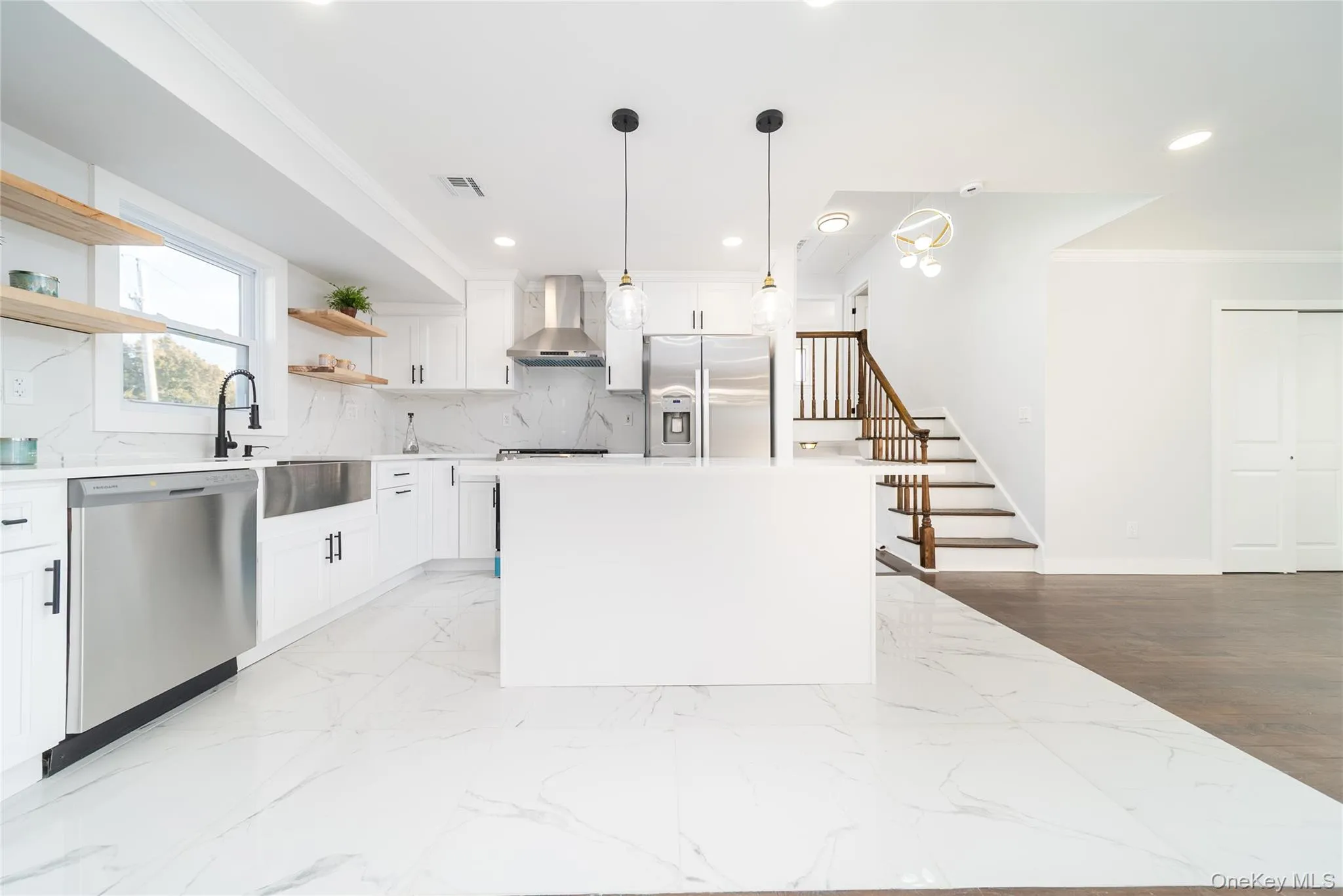 Kitchen with crown molding, white cabinetry, appliances with stainless steel finishes, a center island, and pendant lighting Kitchen with crown molding, white cabinetry, appliances with stainless steel finishes, a center island, and pendant lighting