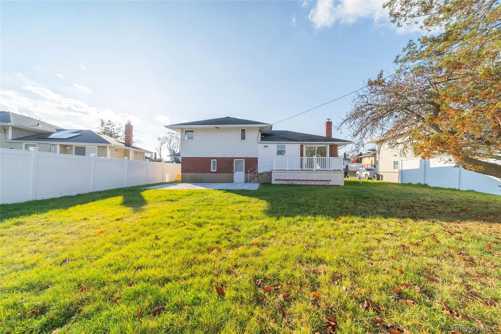 Back of house featuring a fenced backyard, a chimney, brick siding, and a deck Back of house featuring a fenced backyard, a chimney, brick siding, and a deck