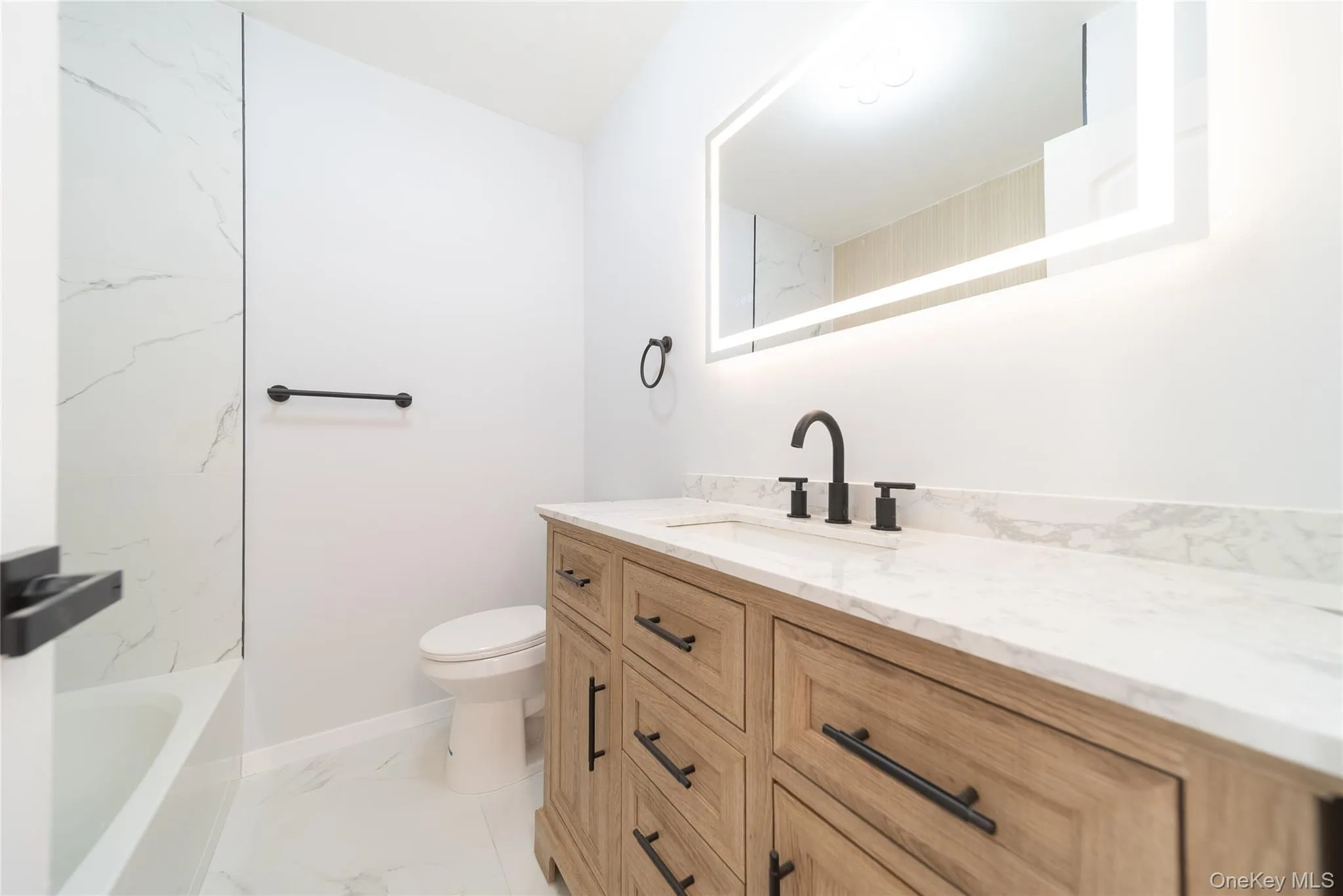 Bathroom with vanity and light marble finish floors Bathroom with vanity and light marble finish floors