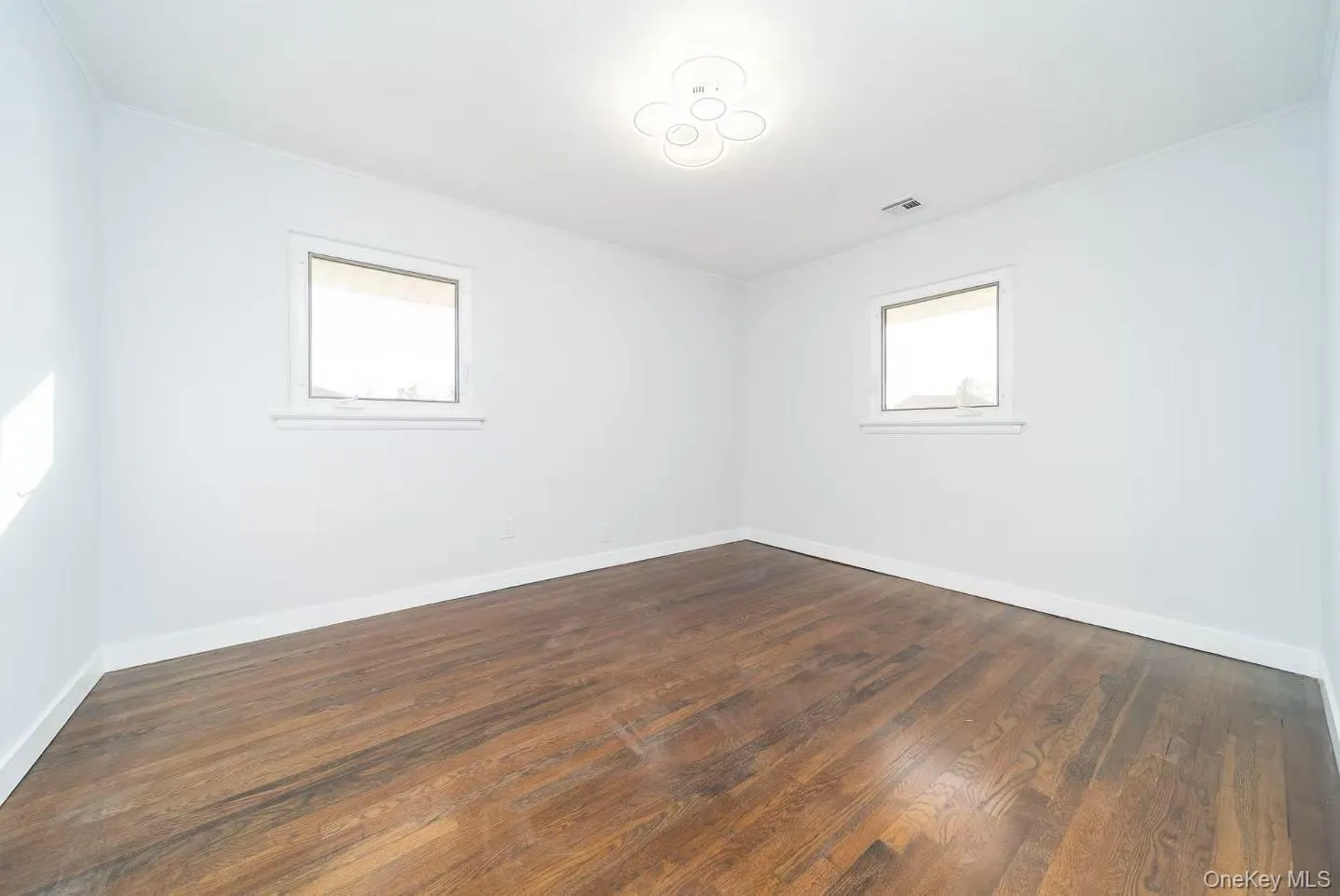 Spare room featuring dark wood finished floors and baseboards Spare room featuring dark wood finished floors and baseboards