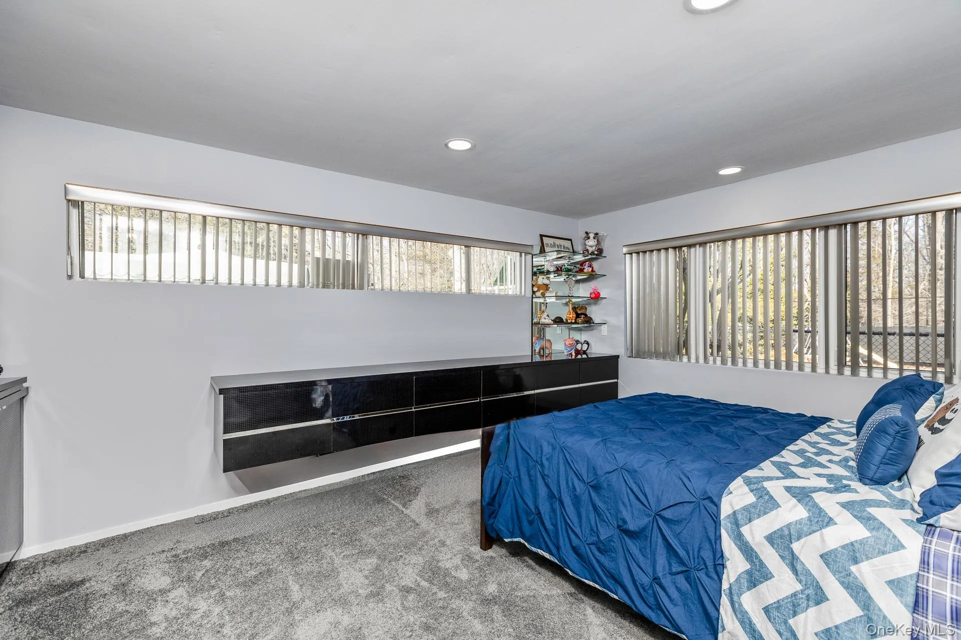 Carpeted bedroom with multiple windows and recessed lighting Carpeted bedroom with multiple windows and recessed lighting