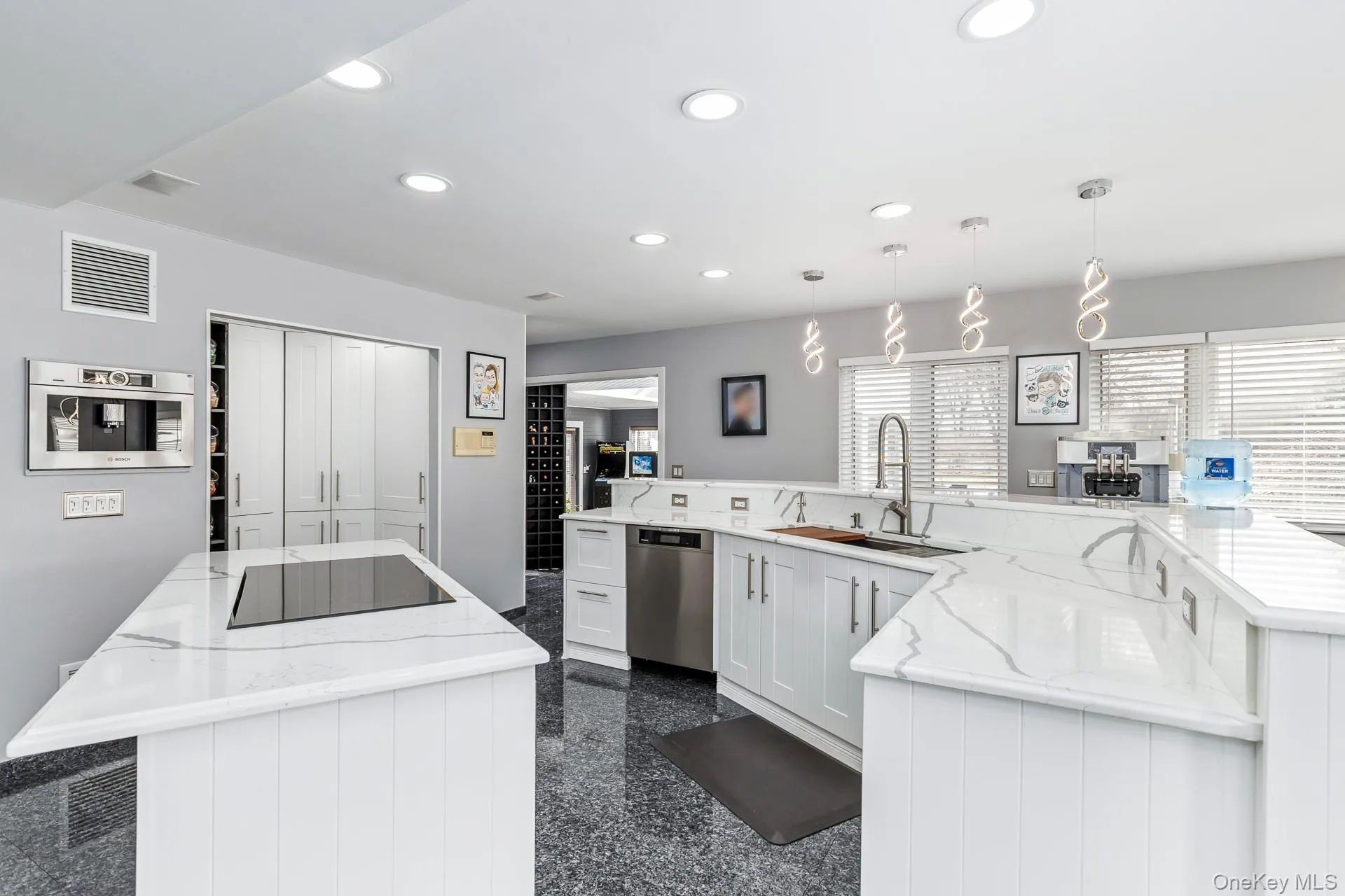 Kitchen with light stone countertops, recessed lighting, hanging light fixtures, stainless steel appliances, and white cabinets Kitchen with light stone countertops, recessed lighting, hanging light fixtures, stainless steel appliances, and white cabinets