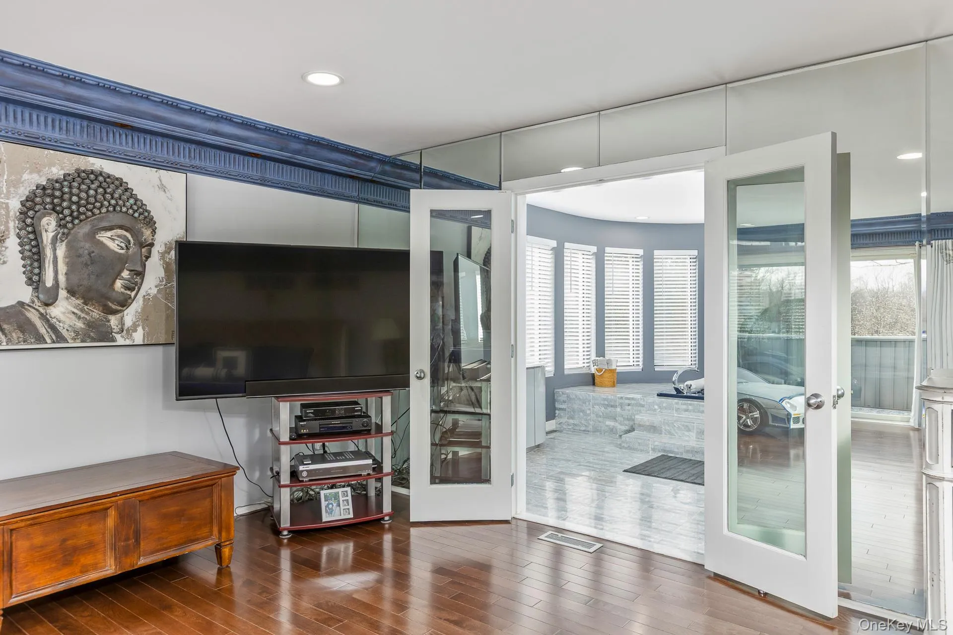 Living area featuring wood-type flooring, healthy amount of natural light, french doors, and recessed lighting Living area featuring wood-type flooring, healthy amount of natural light, french doors, and recessed lighting