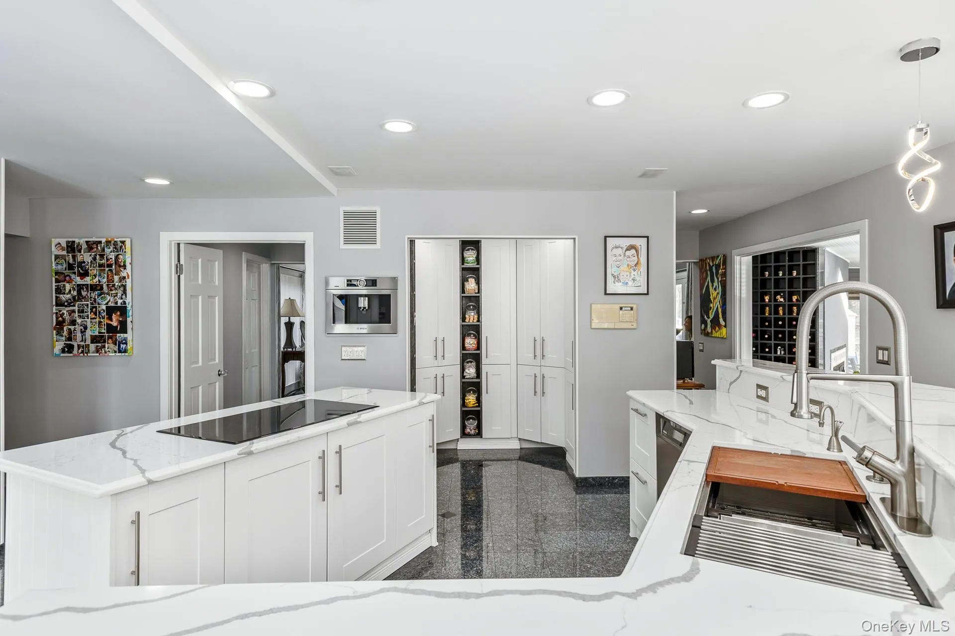 Kitchen with granite tiled floors, light stone counters, pendant lighting, black electric stovetop, and recessed lighting Kitchen with granite tiled floors, light stone counters, pendant lighting, black electric stovetop, and recessed lighting