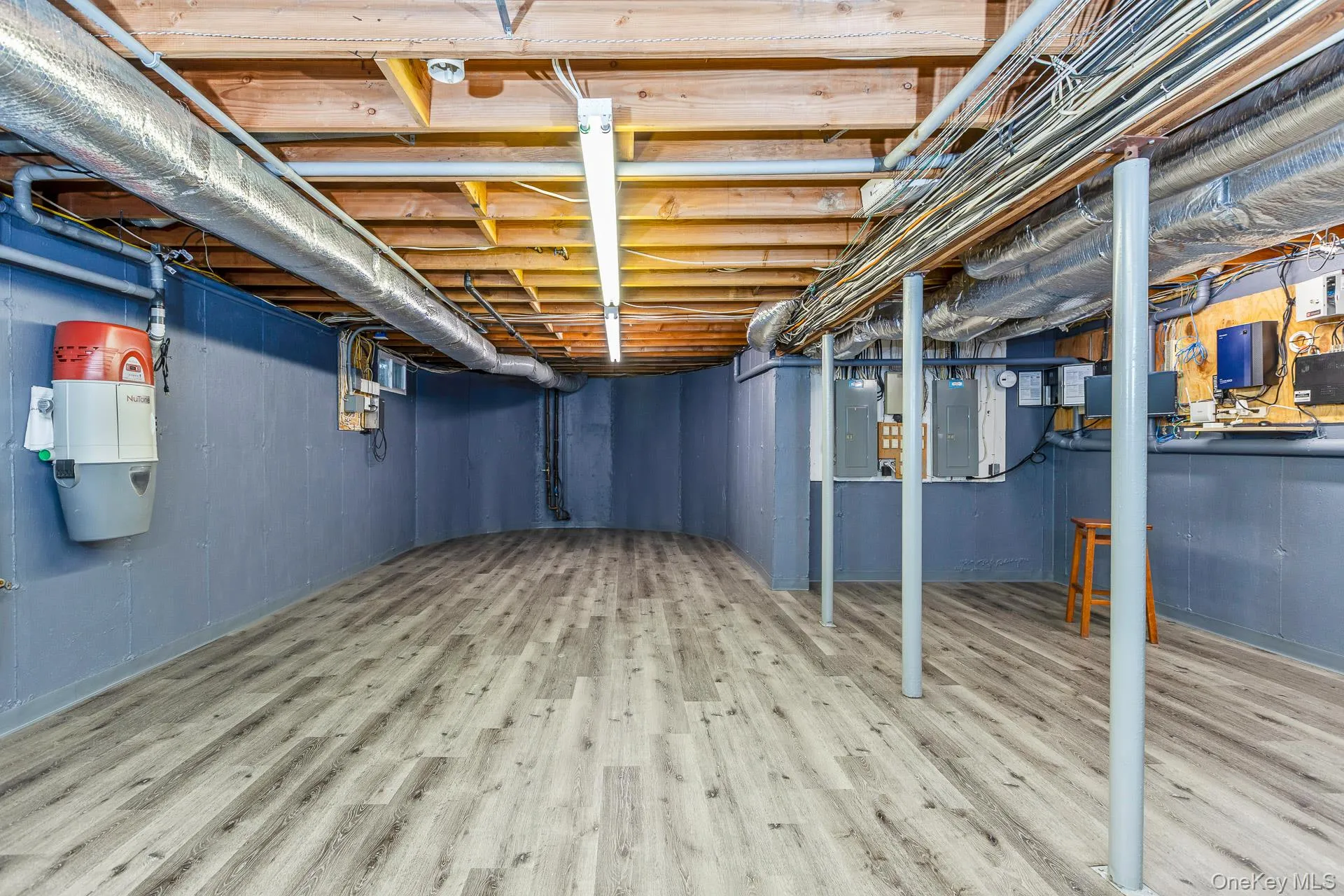 Unfinished basement featuring light wood-style floors and electric panel Unfinished basement featuring light wood-style floors and electric panel