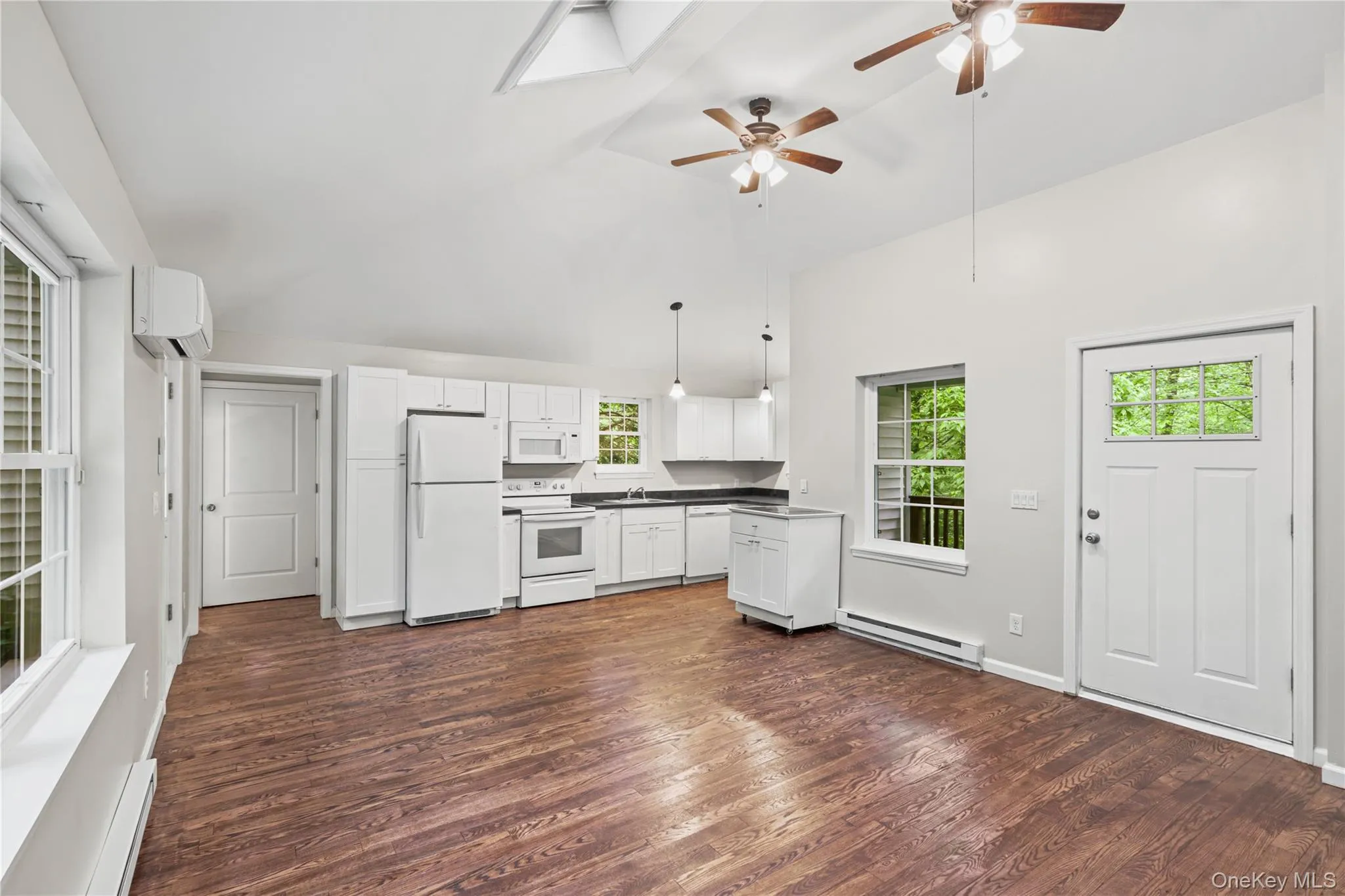 Open concept living featuring high vaulted ceiling with newly finished hardwood floors and ceiling fans. Open concept living featuring high vaulted ceiling with newly finished hardwood floors and ceiling fans.