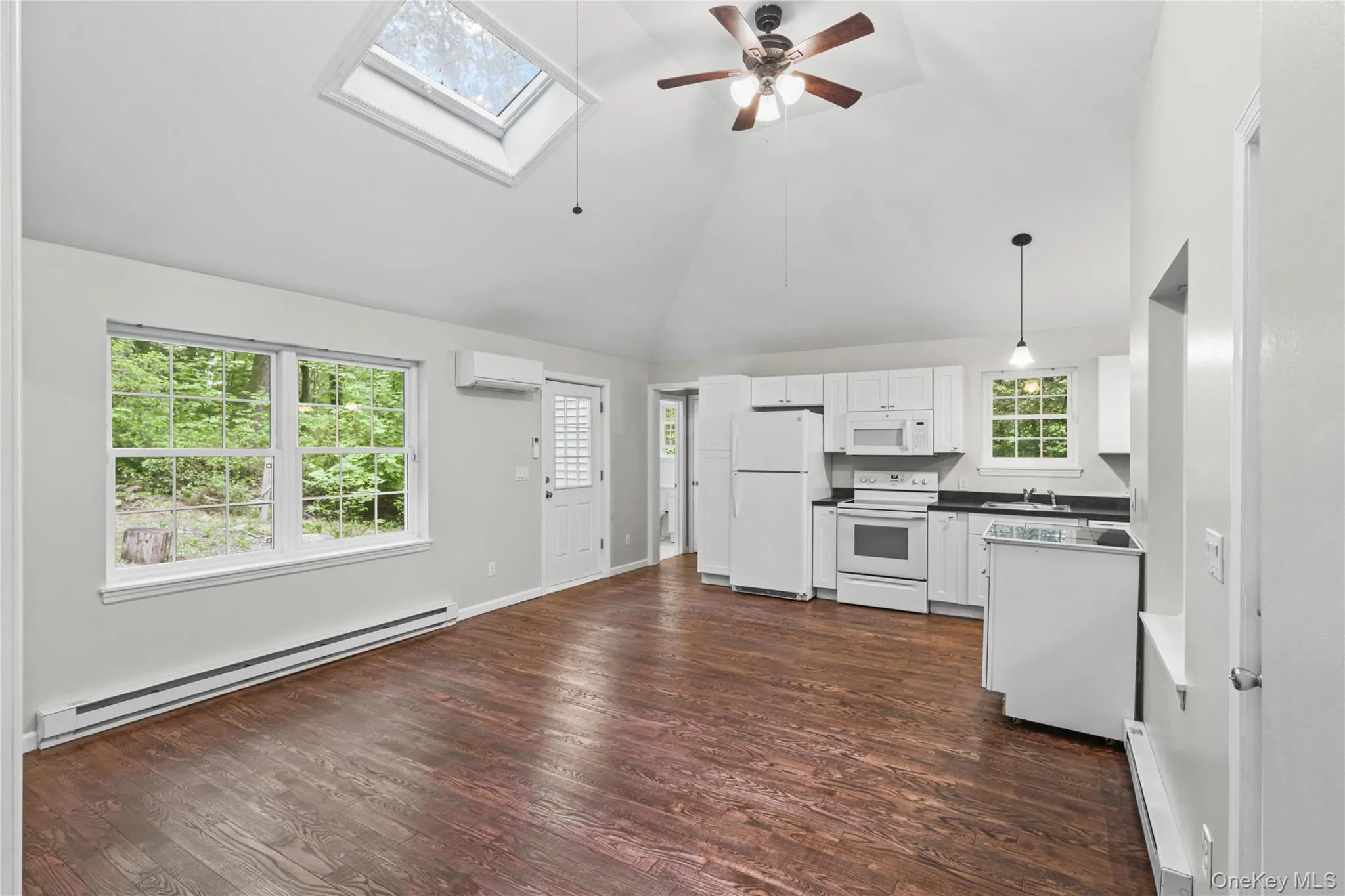 Open concept living featuring high vaulted ceiling with newly finished hardwood floors and ceiling fans. Open concept living featuring high vaulted ceiling with newly finished hardwood floors and ceiling fans.