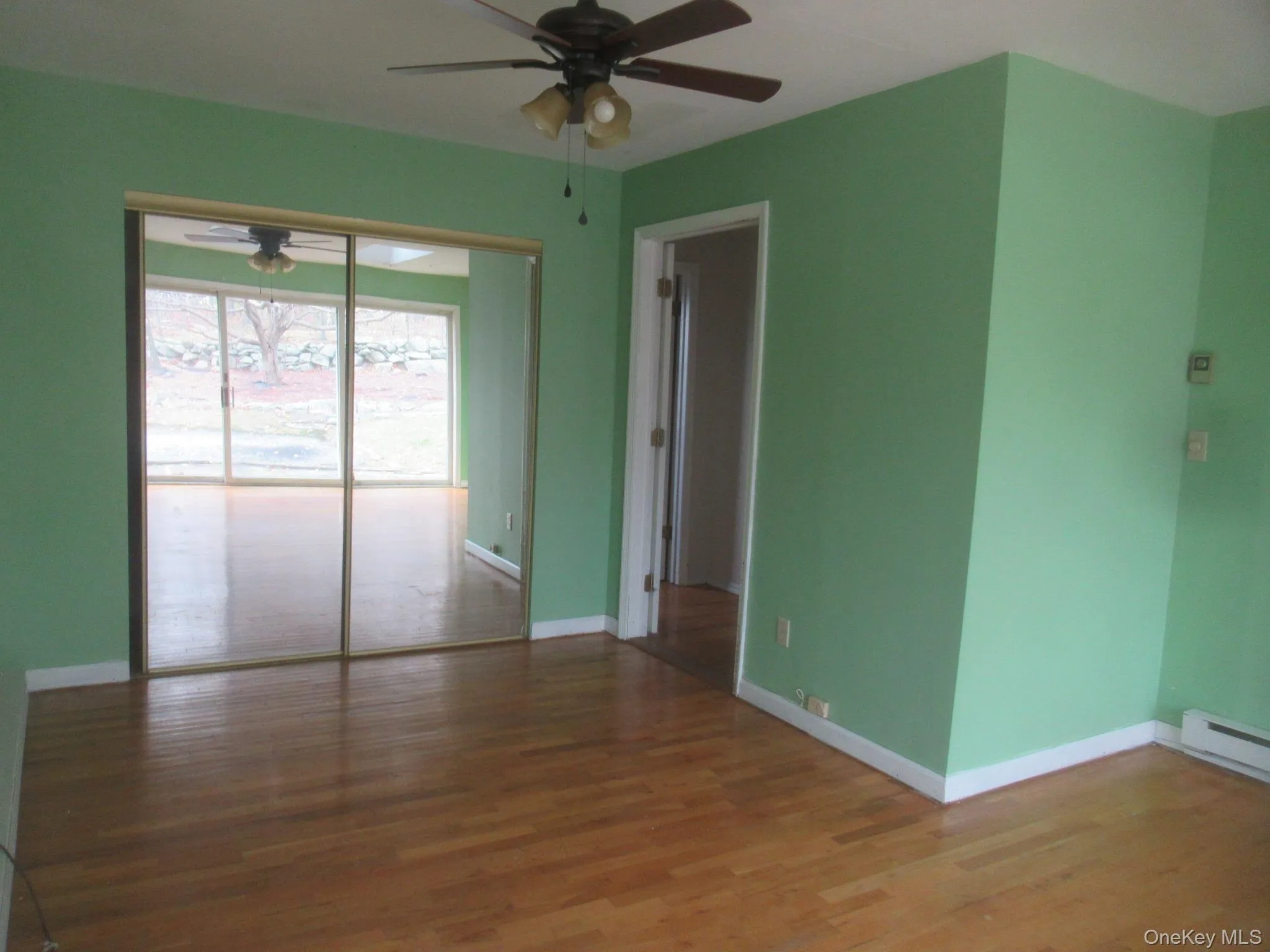 Unfurnished room with wood finished floors and ceiling fan Unfurnished room with wood finished floors and ceiling fan