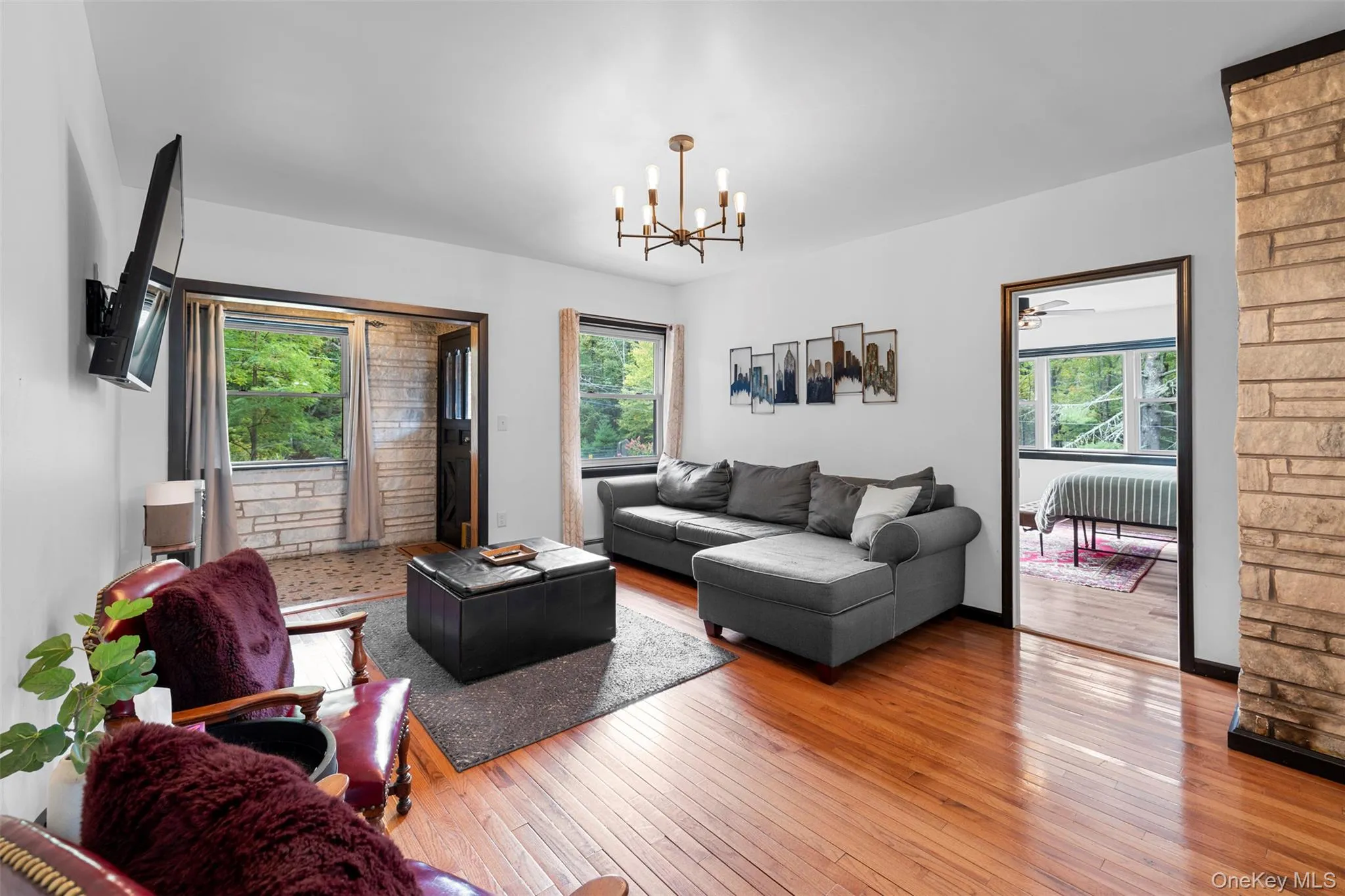 Living room with hardwood / wood-style flooring, a chandelier, and ceiling fan Living room with hardwood / wood-style flooring, a chandelier, and ceiling fan