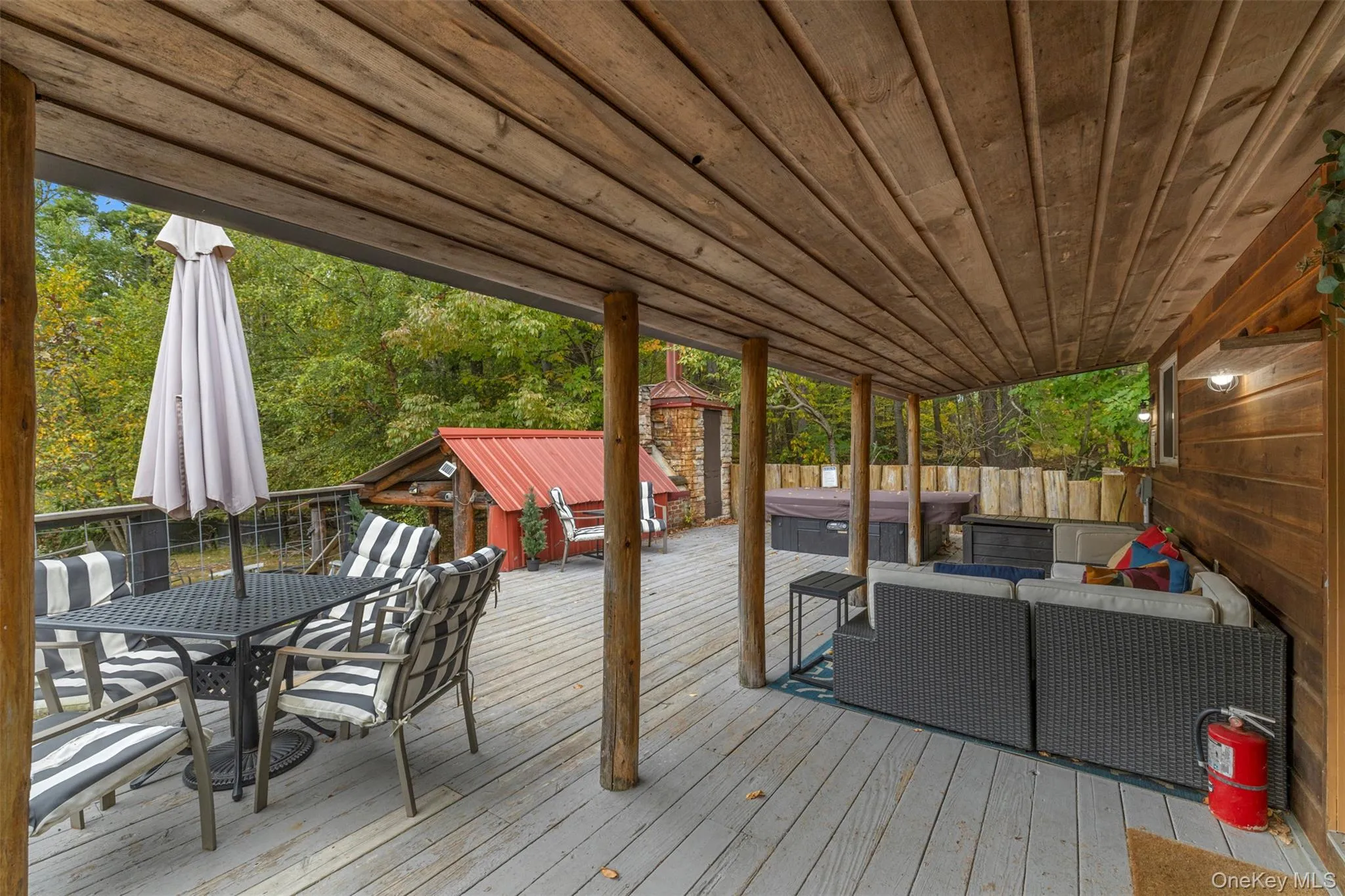 Wooden deck with a hot tub, an outdoor living space, and outdoor dining space Wooden deck with a hot tub, an outdoor living space, and outdoor dining space