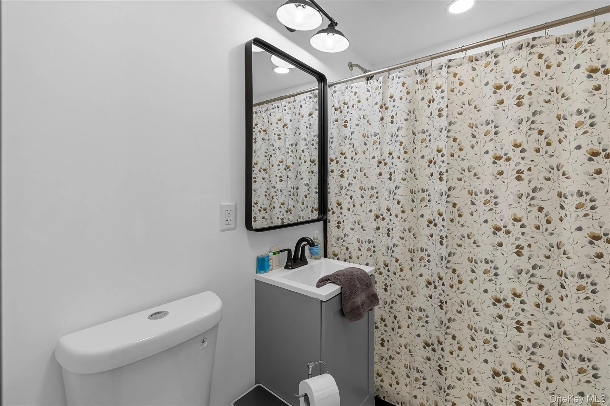 Bathroom with vanity, recessed lighting, and curtained shower Bathroom with vanity, recessed lighting, and curtained shower