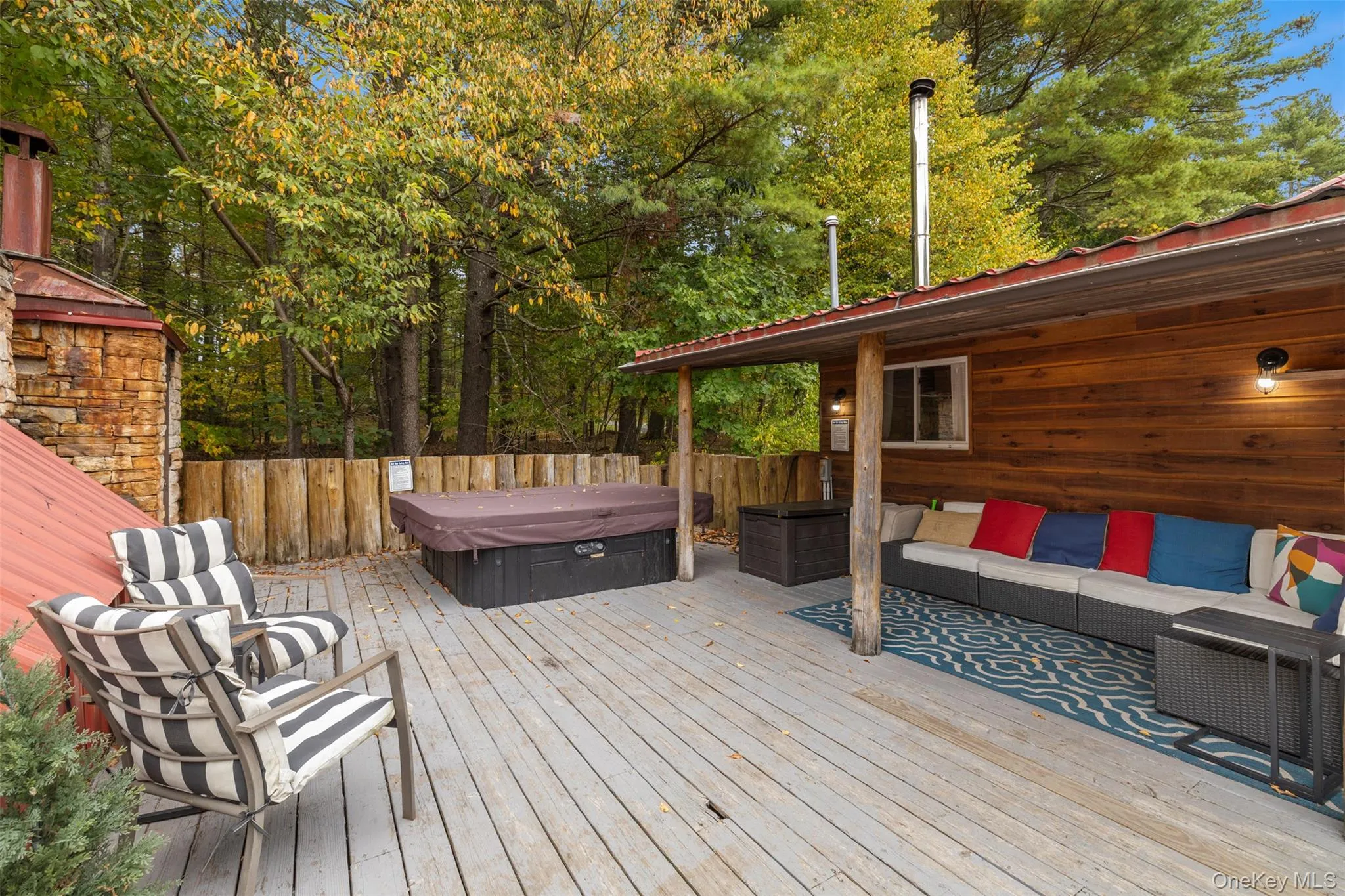 Wooden deck featuring a covered hot tub and an outdoor living space Wooden deck featuring a covered hot tub and an outdoor living space