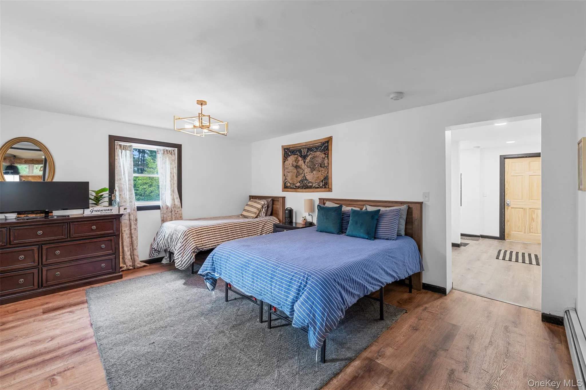 Bedroom with light wood-style floors and baseboard heating Bedroom with light wood-style floors and baseboard heating