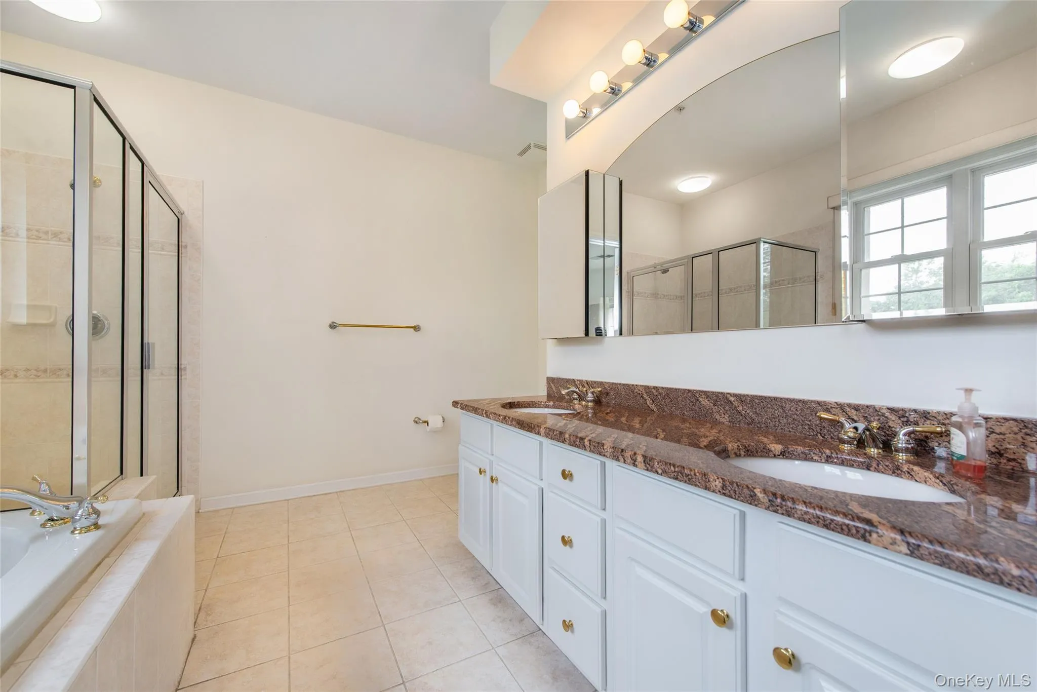Double vanity with integrated sinks, granite countertop, and white cabinetry Double vanity with integrated sinks, granite countertop, and white cabinetry