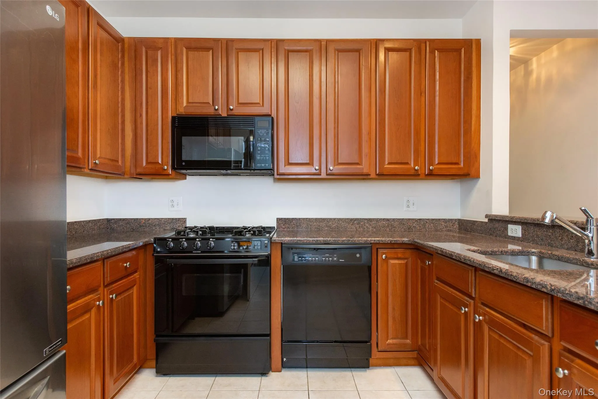 U-shaped kitchen with wood cabinetry and dark granite-style countertops U-shaped kitchen with wood cabinetry and dark granite-style countertops