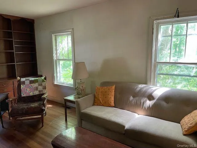 Sunlit living room with wood floors, brick fireplace and built-in book shelves Sunlit living room with wood floors, brick fireplace and built-in book shelves