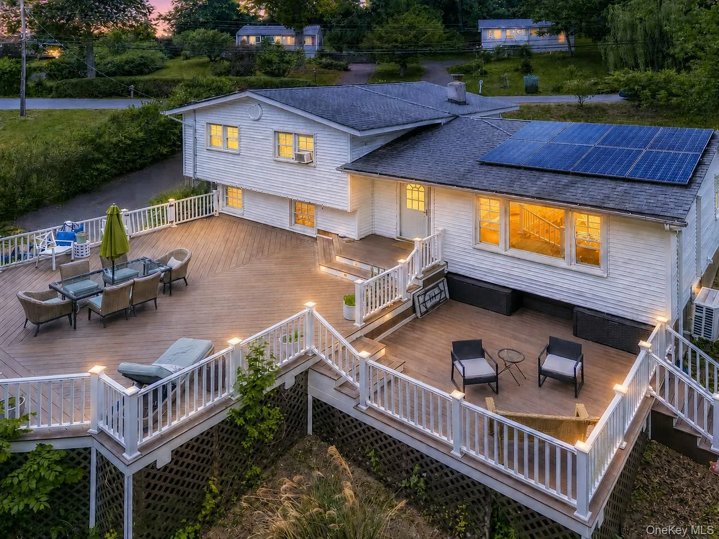 Multi-level outdoor deck featuring recessed lighting, white railings, and a large dining area Multi-level outdoor deck featuring recessed lighting, white railings, and a large dining area