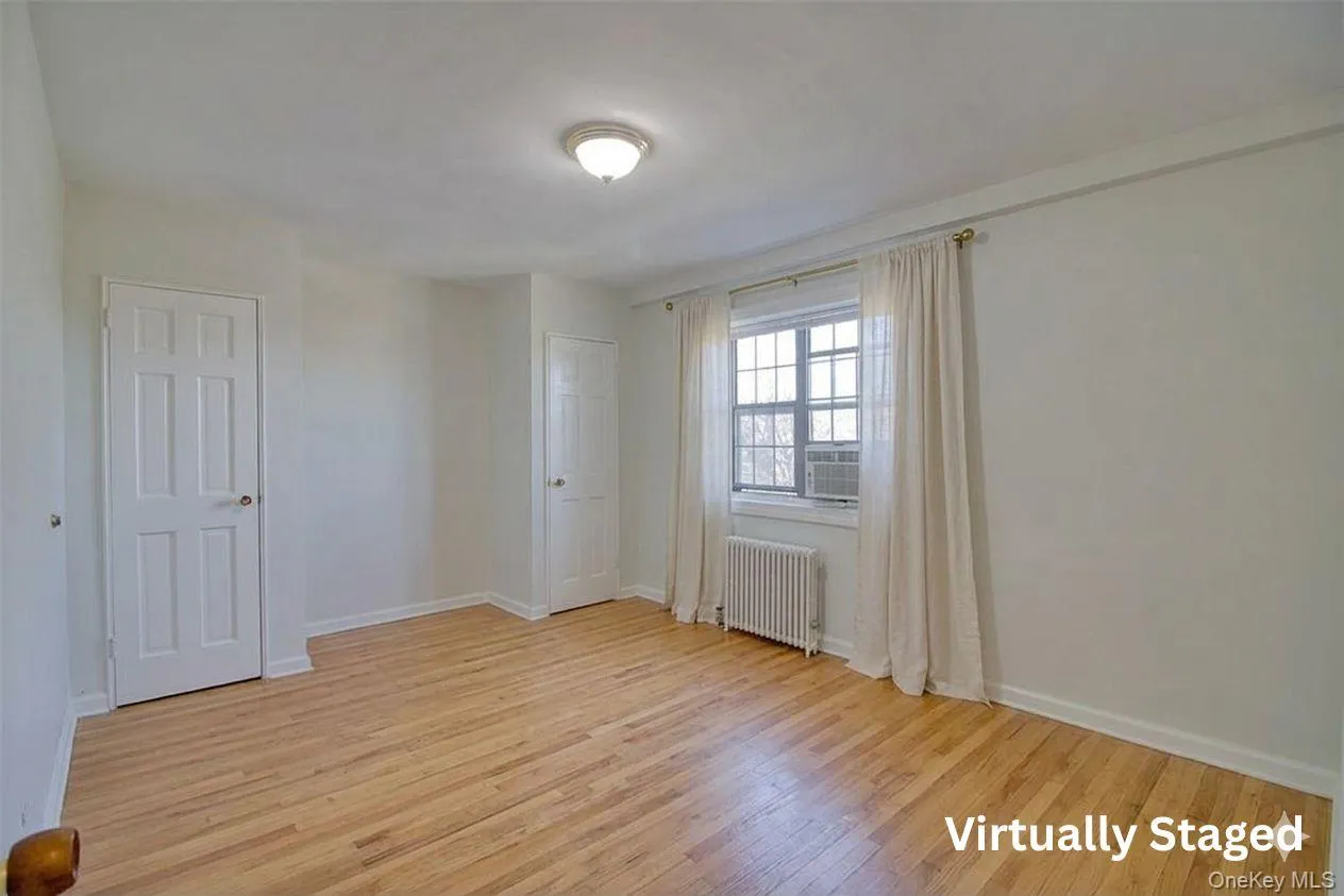 Virtually Staged. Bedroom with baseboards, cooling unit, and radiator heating unit Virtually Staged. Bedroom with baseboards, cooling unit, and radiator heating unit