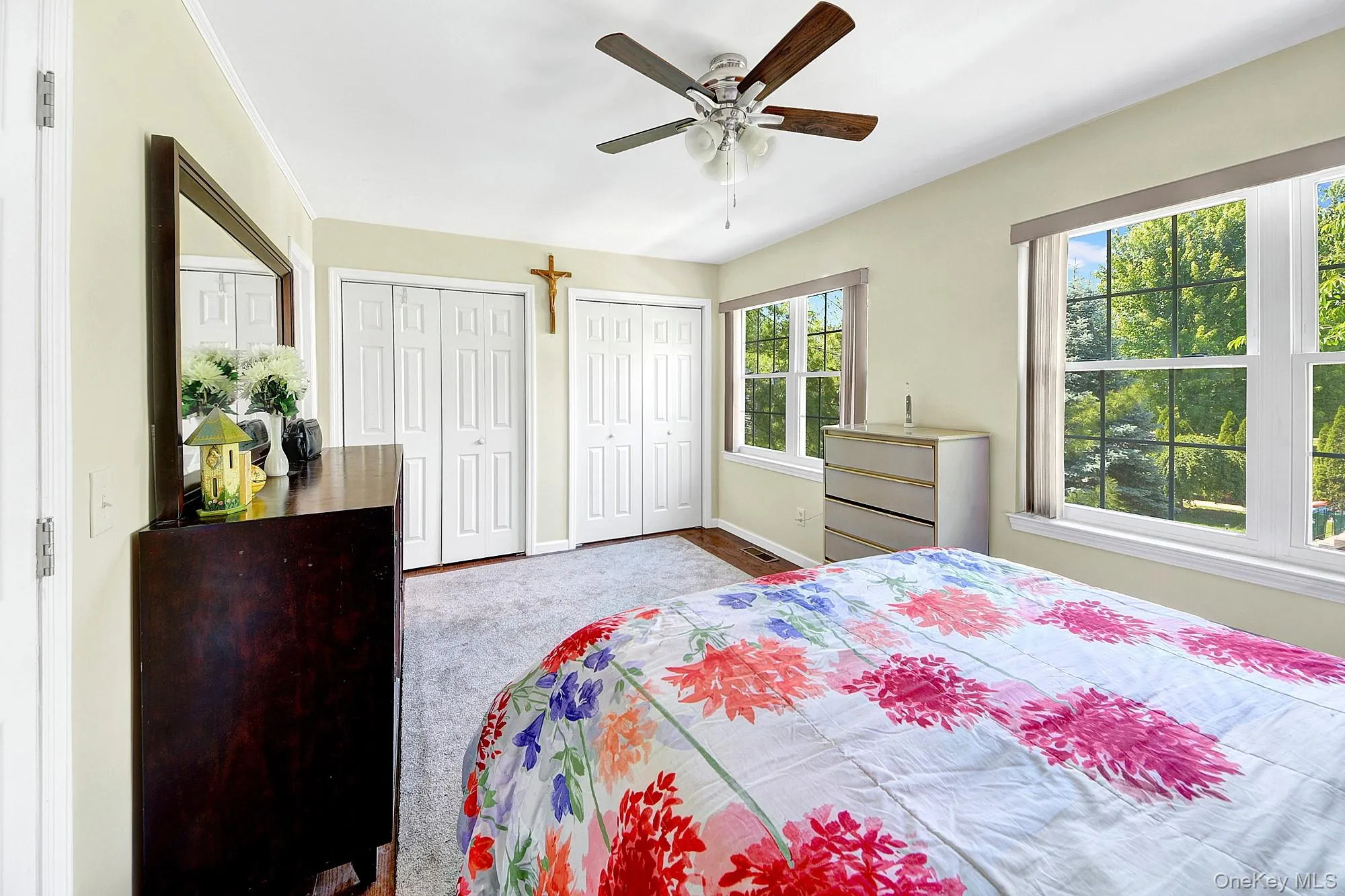 Primary bedroom with large windows, large closets, hardwood floors and an en-suite bathroom Primary bedroom with large windows, large closets, hardwood floors and an en-suite bathroom
