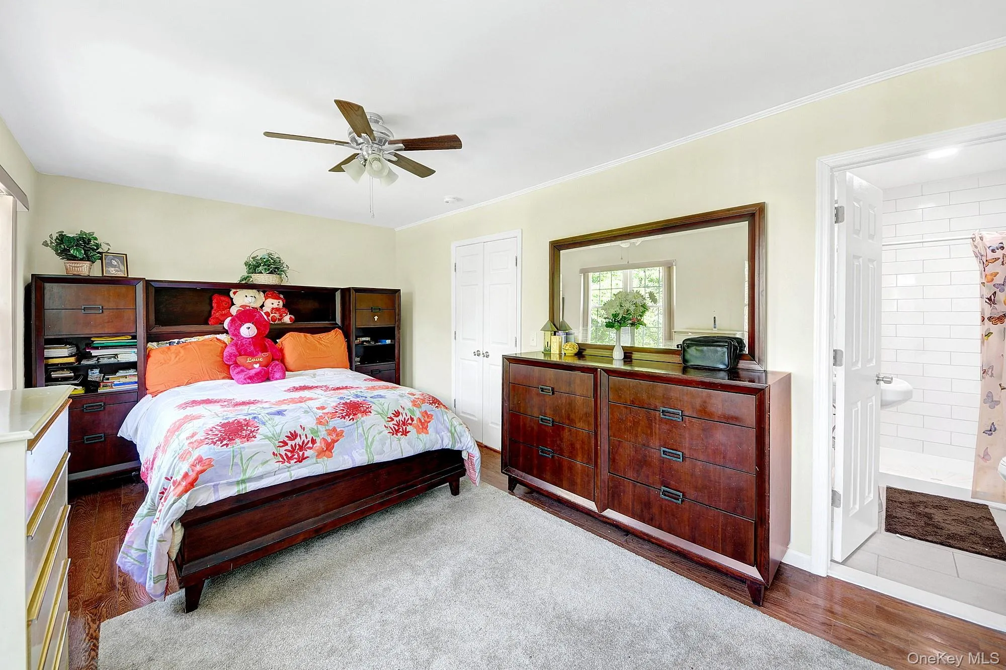 Primary bedroom with large windows, large closets, hardwood floors and an en-suite bathroom Primary bedroom with large windows, large closets, hardwood floors and an en-suite bathroom