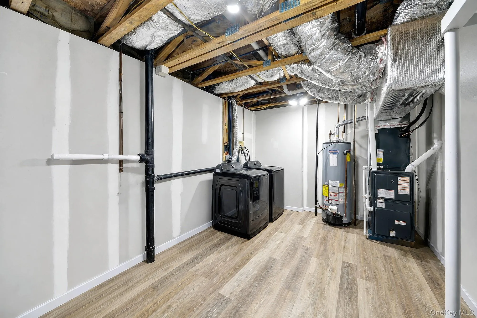 Utility room with forced air heating and cooling system and washer/dryer units Utility room with forced air heating and cooling system and washer/dryer units